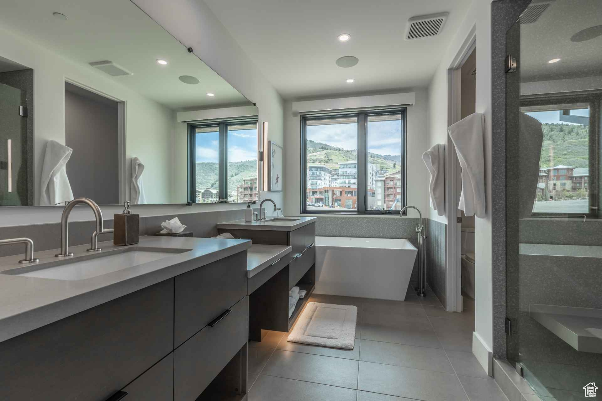 Bathroom with tile patterned flooring, vanity, and plus walk in shower