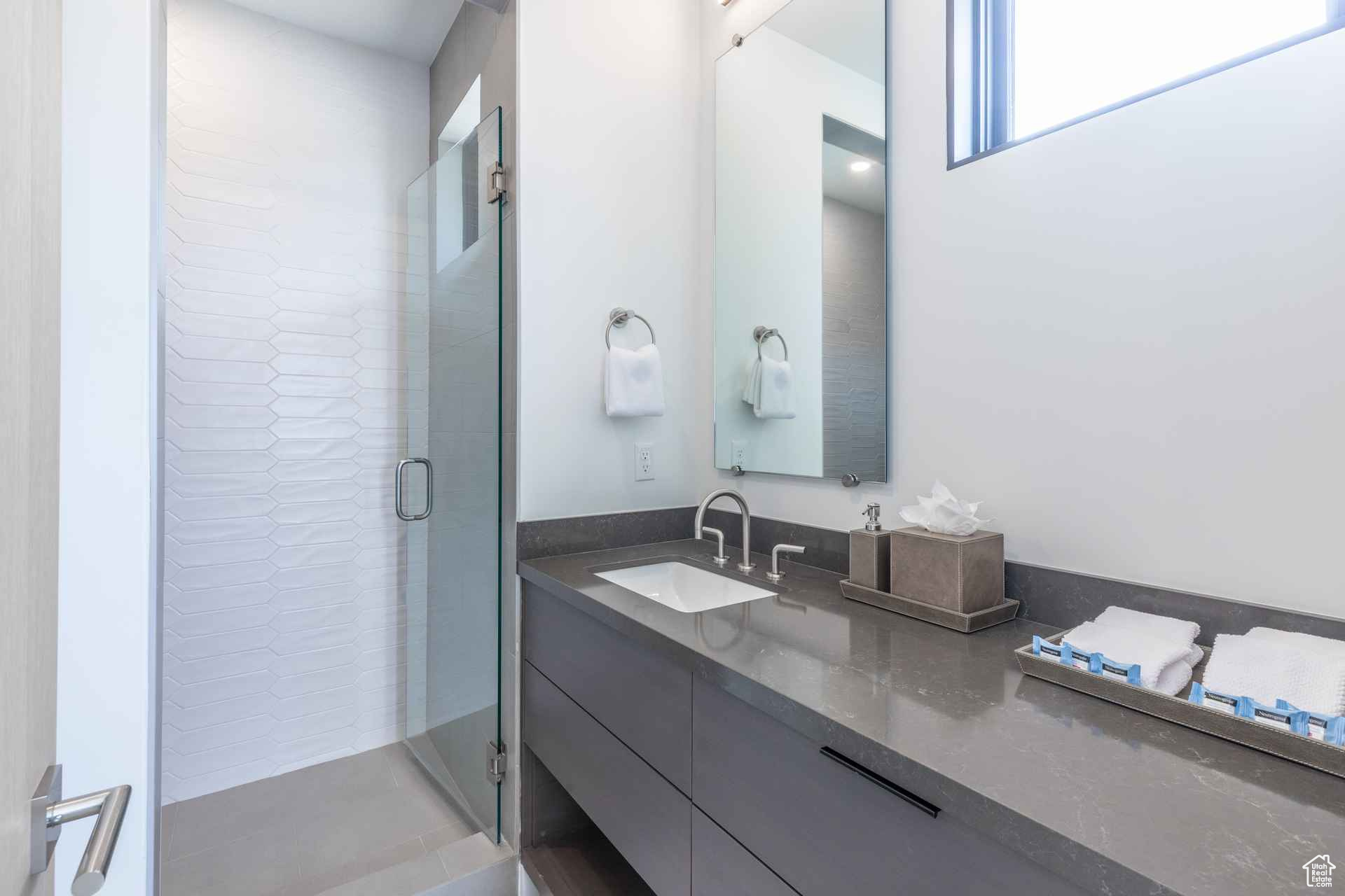 Bathroom with vanity and a shower with shower door