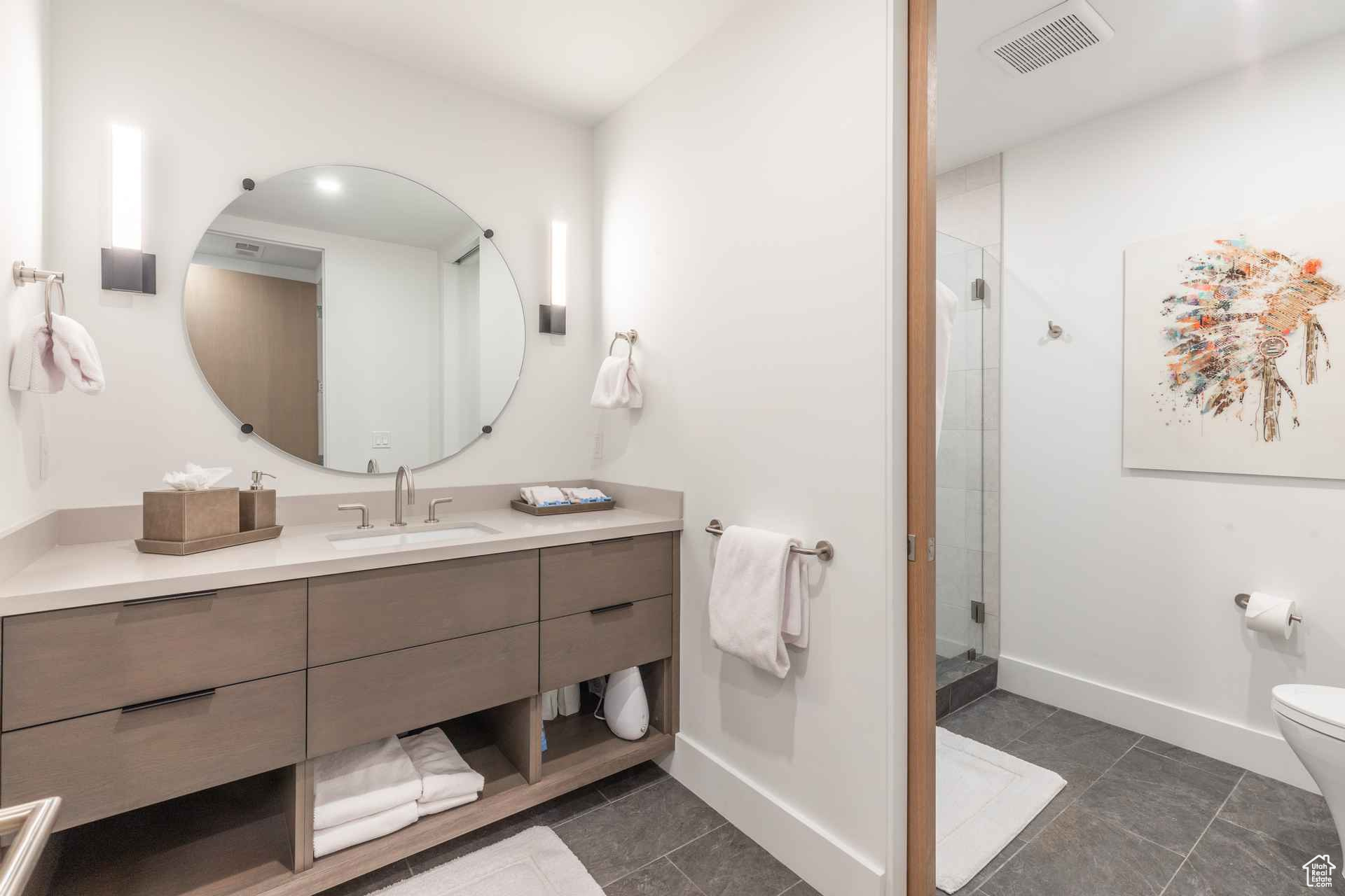 Bathroom with tile patterned flooring, toilet, vanity, and walk in shower