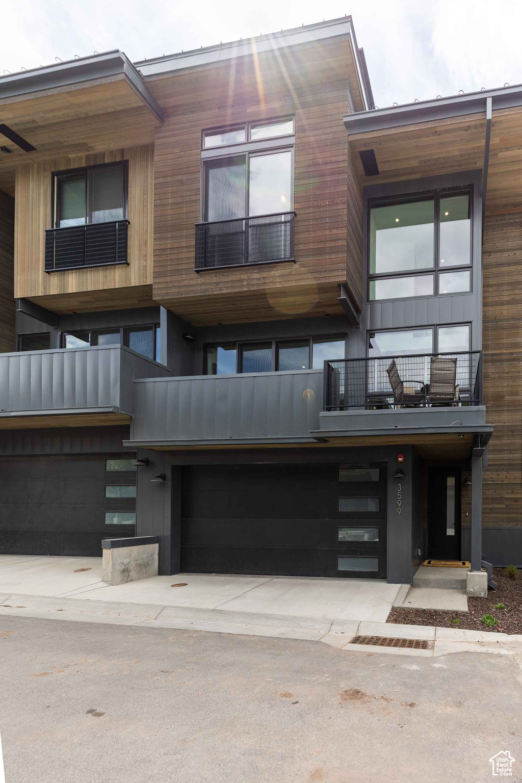 View of front facade featuring a balcony and a garage