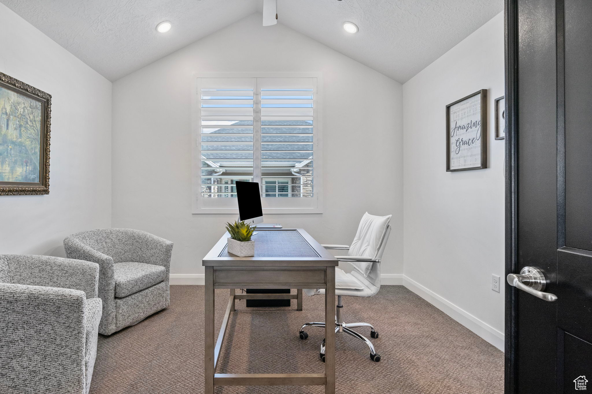 Carpeted home office featuring a textured ceiling and vaulted ceiling with beams