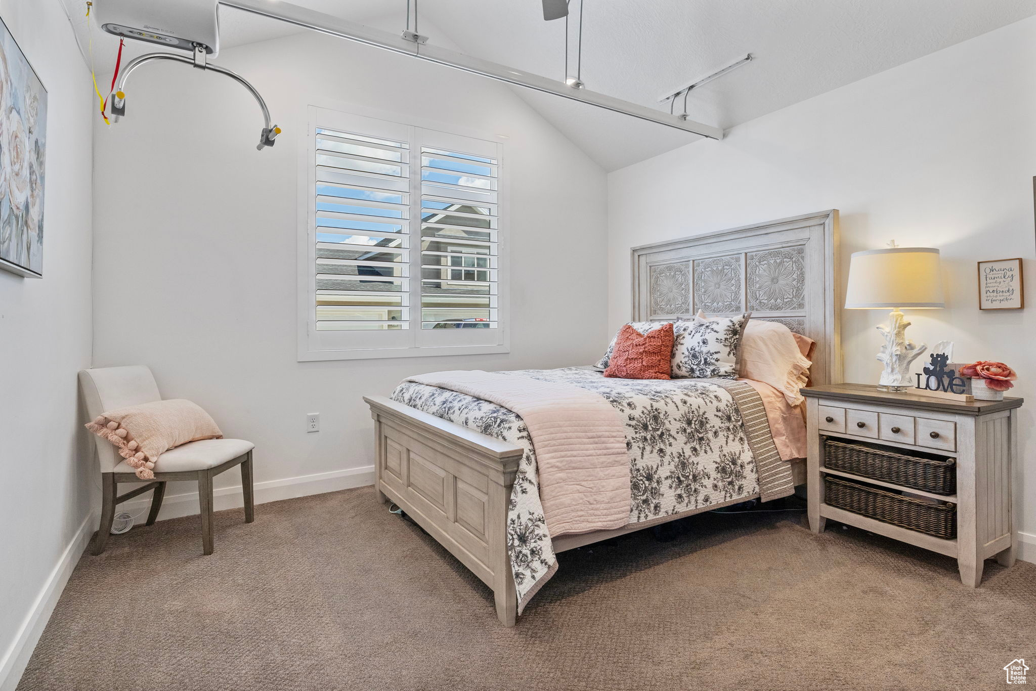 Carpeted bedroom featuring ceiling fan and lofted ceiling