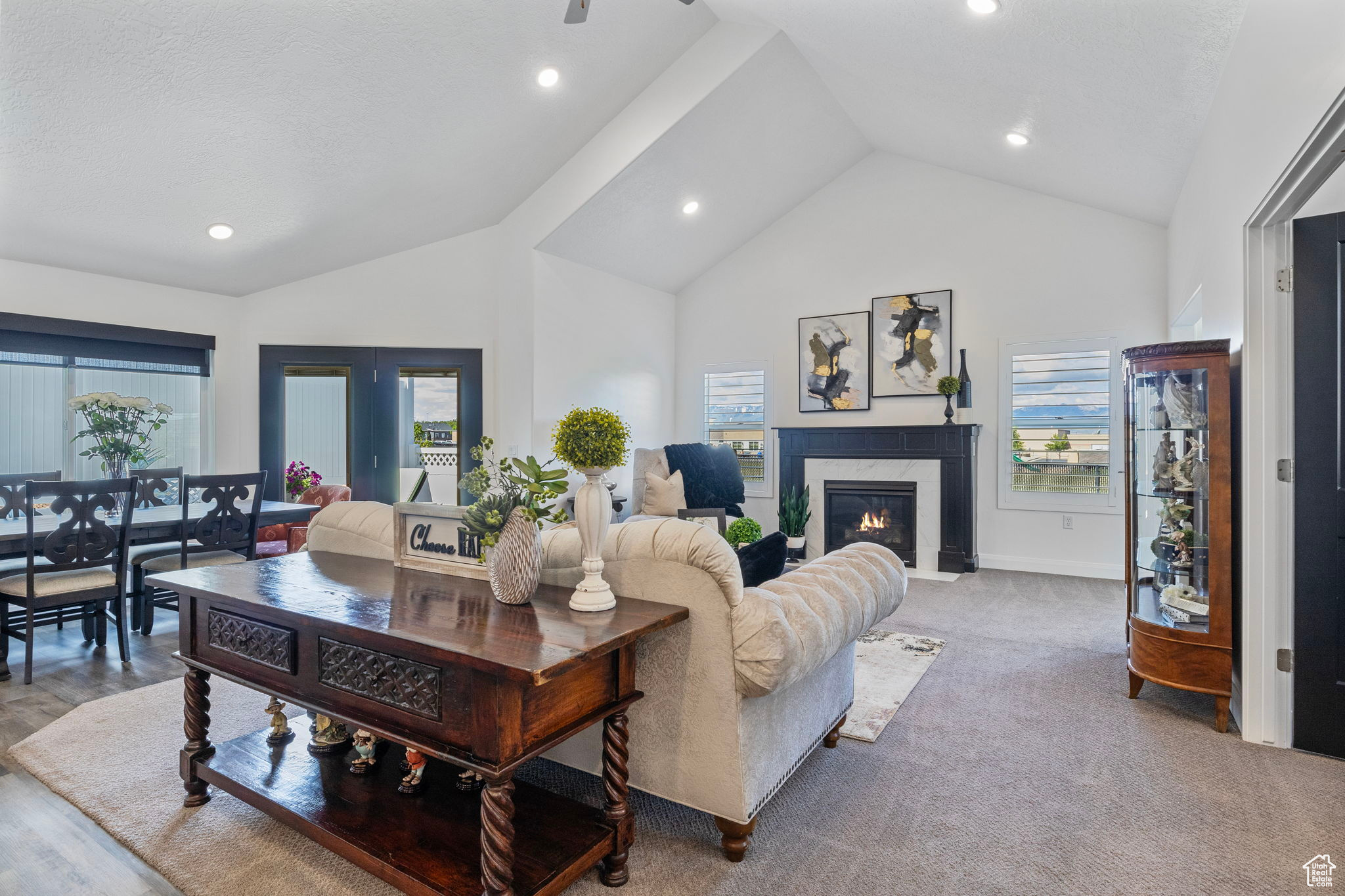 Living room featuring high vaulted ceiling and a high end fireplace