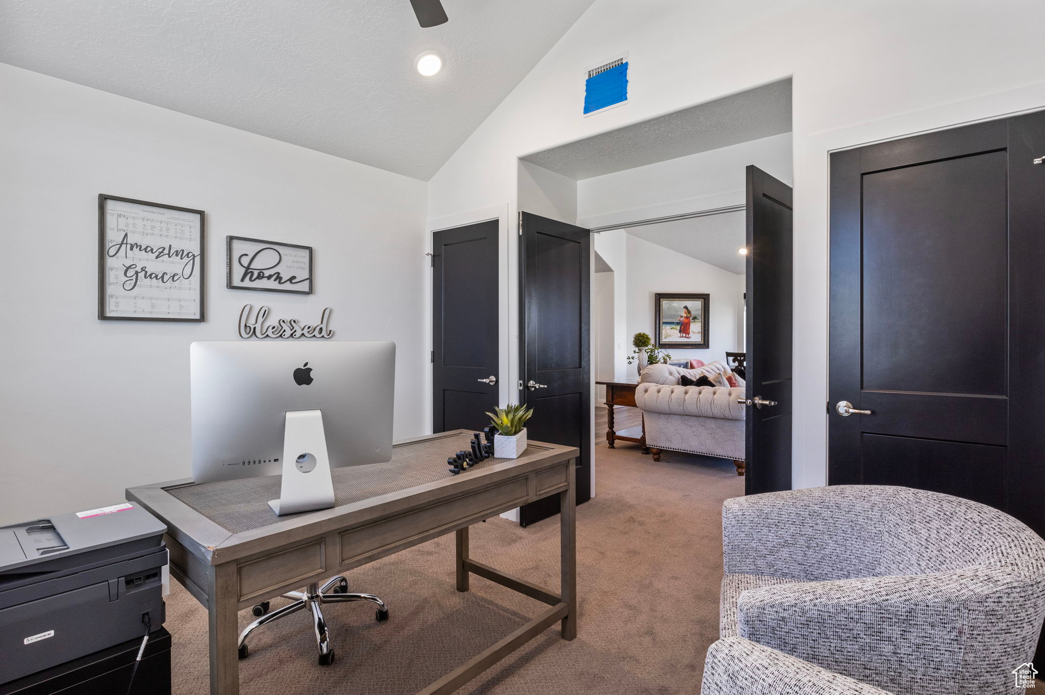 Carpeted office space featuring lofted ceiling