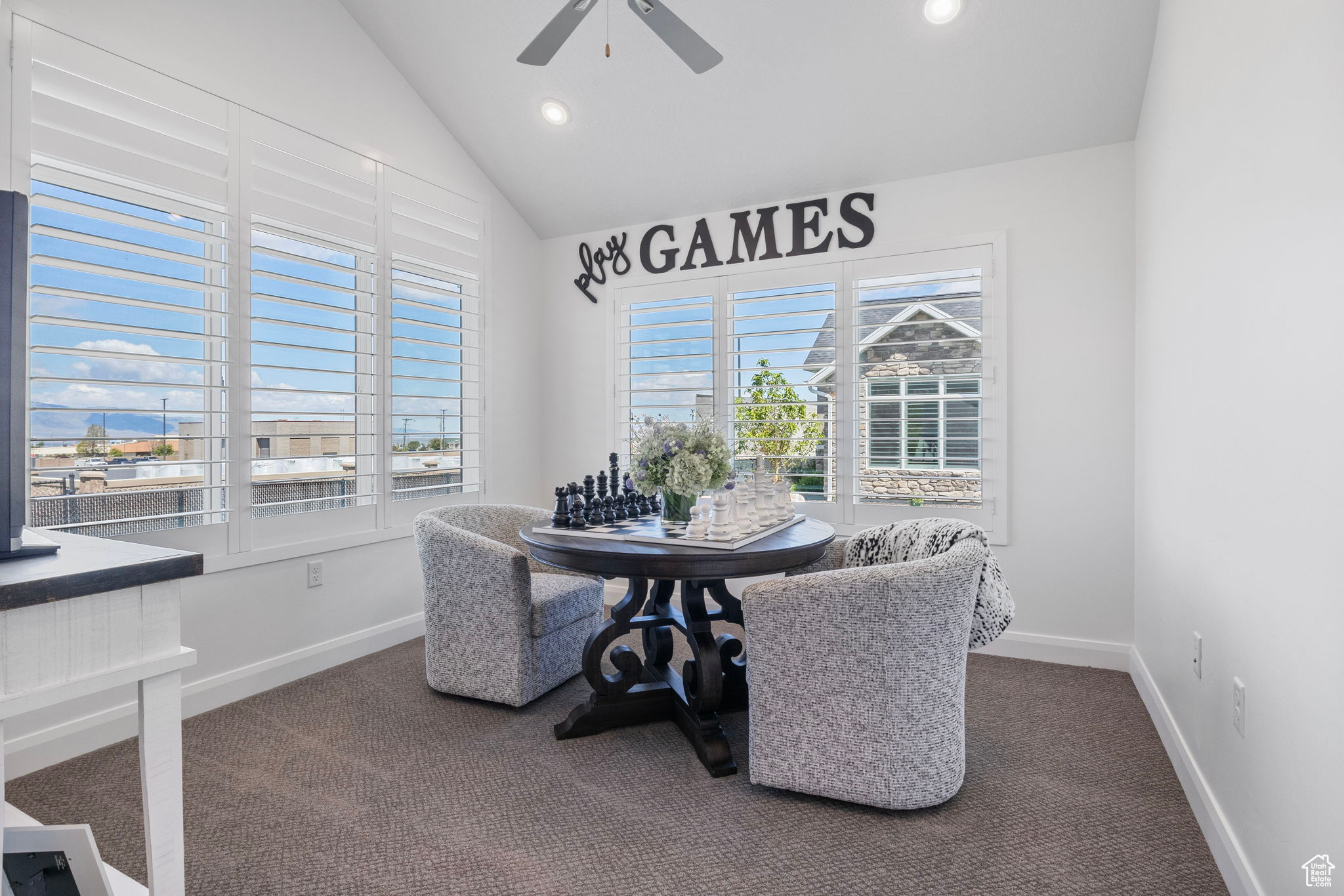 Dining area featuring ceiling fan, carpet, and vaulted ceiling