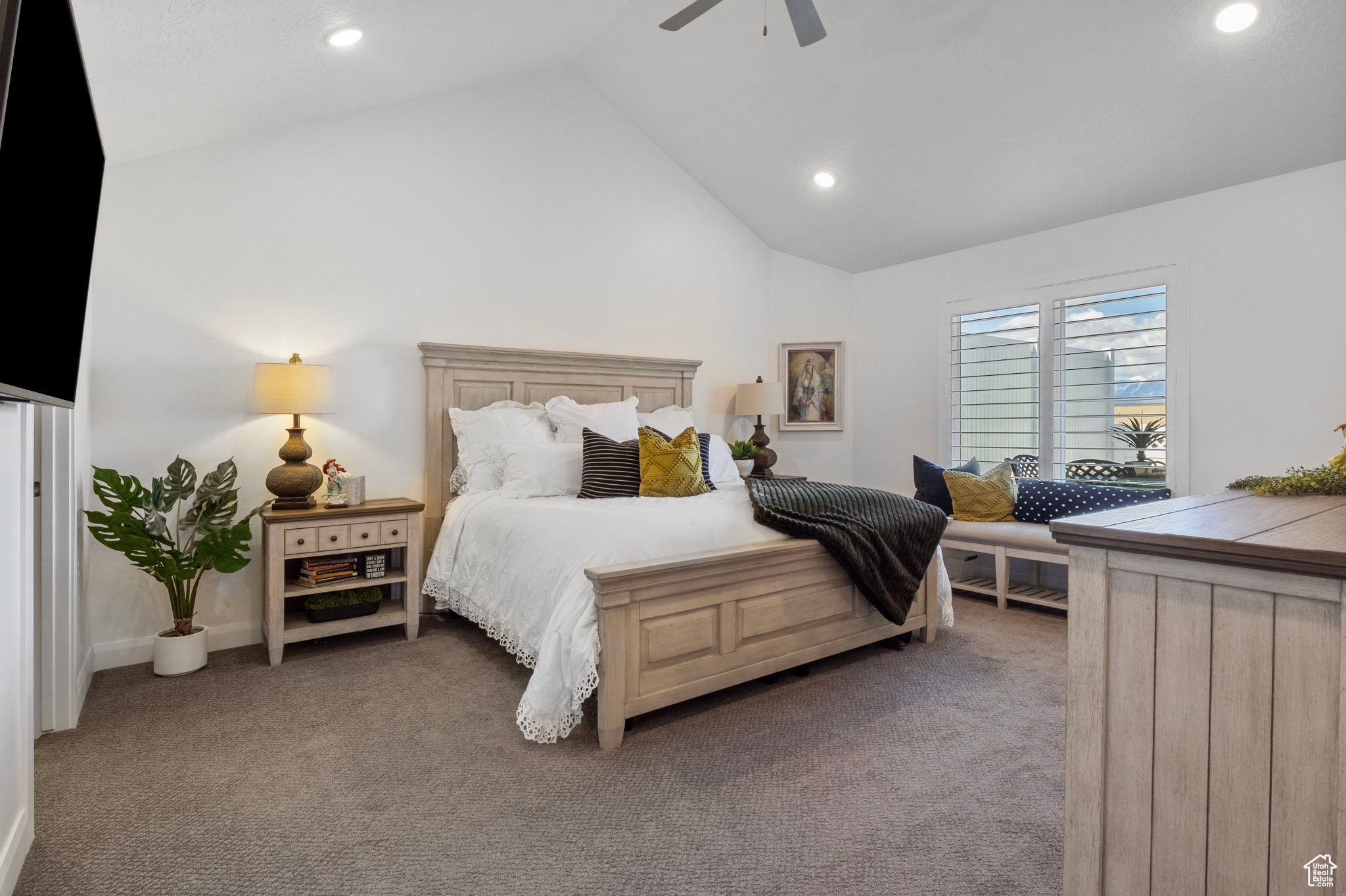 Carpeted bedroom with ceiling fan and high vaulted ceiling