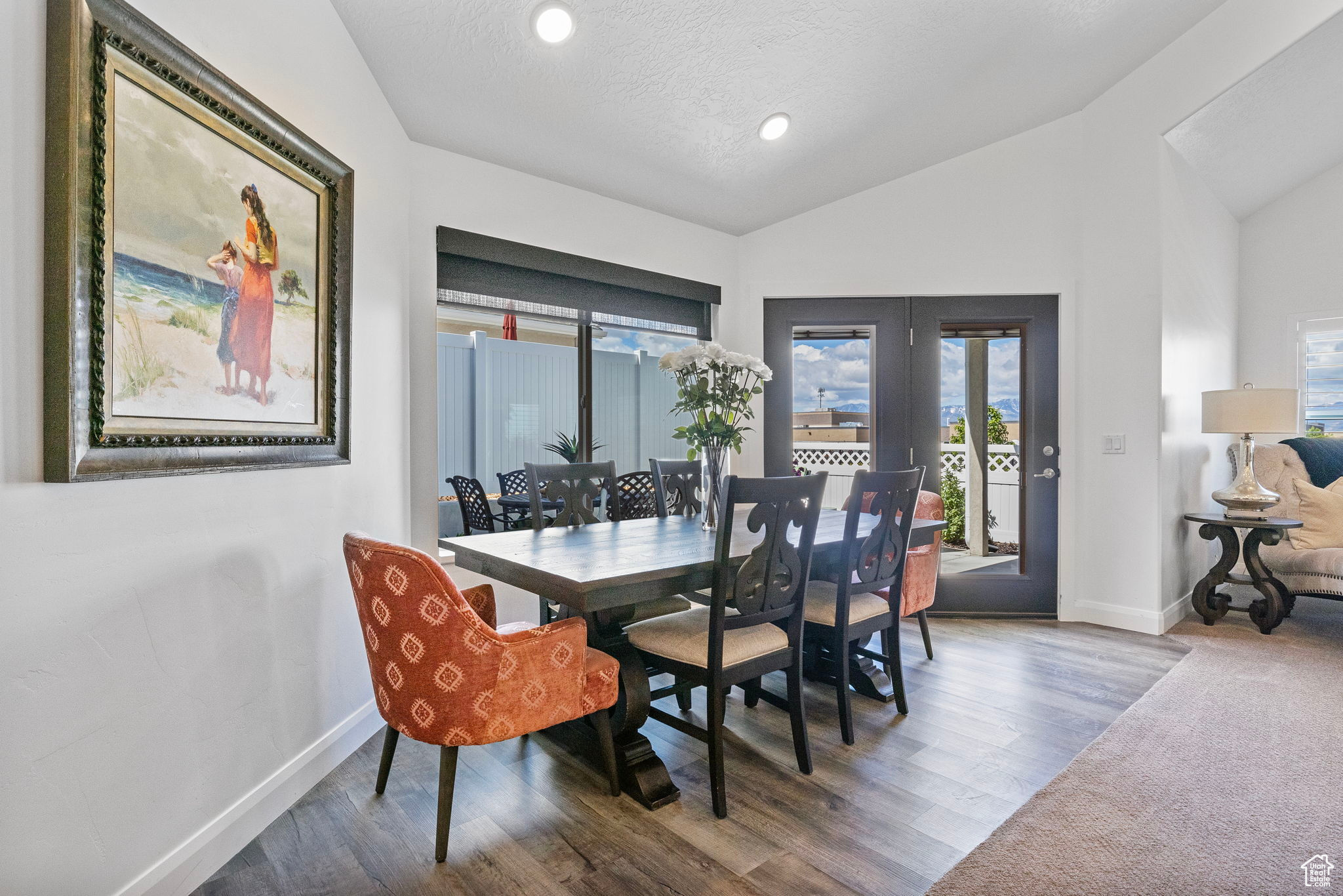 Dining room featuring hardwood / wood-style floors, a textured ceiling, a wealth of natural light, and lofted ceiling