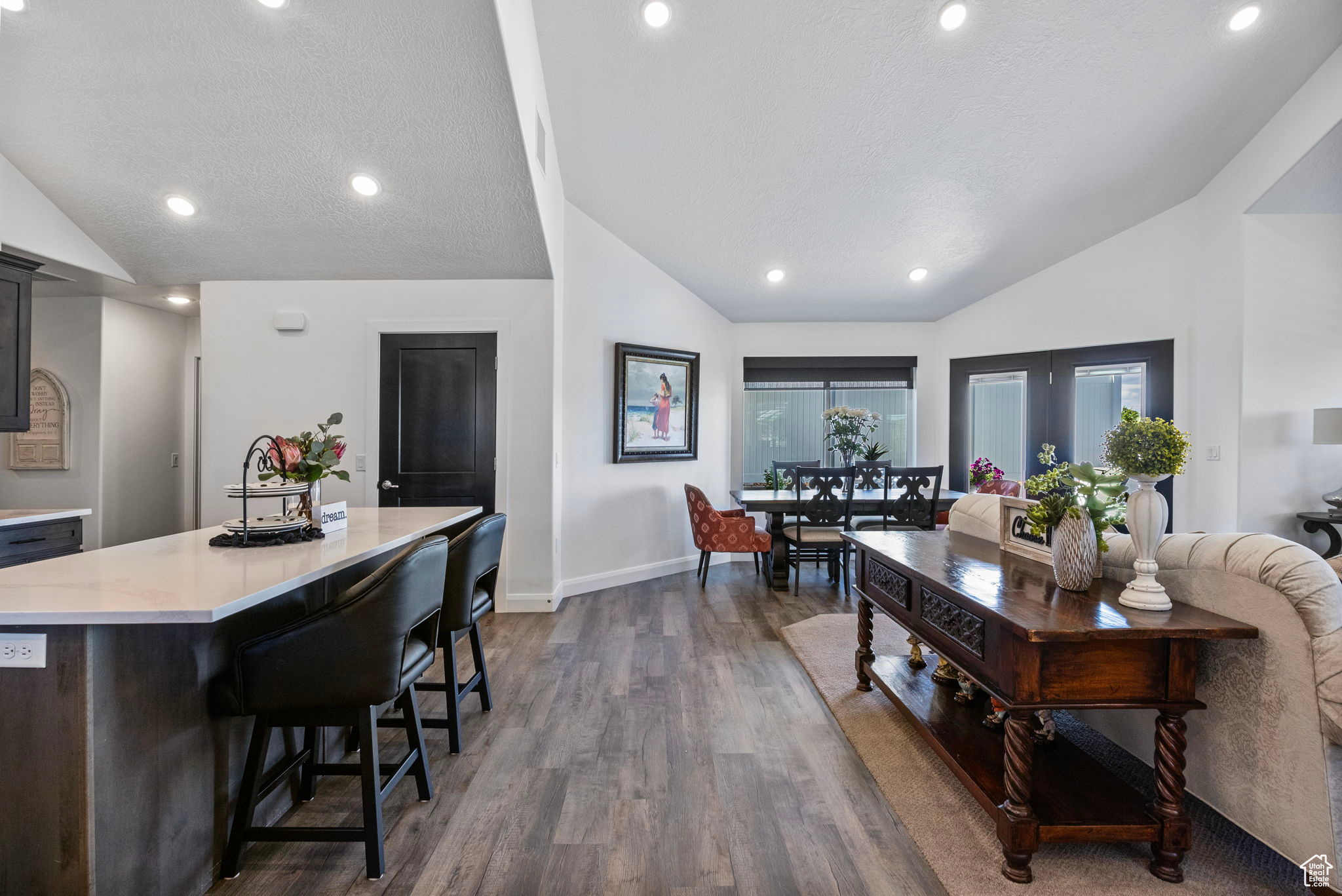 Interior space featuring a textured ceiling, dark hardwood / wood-style flooring, a kitchen island, and lofted ceiling