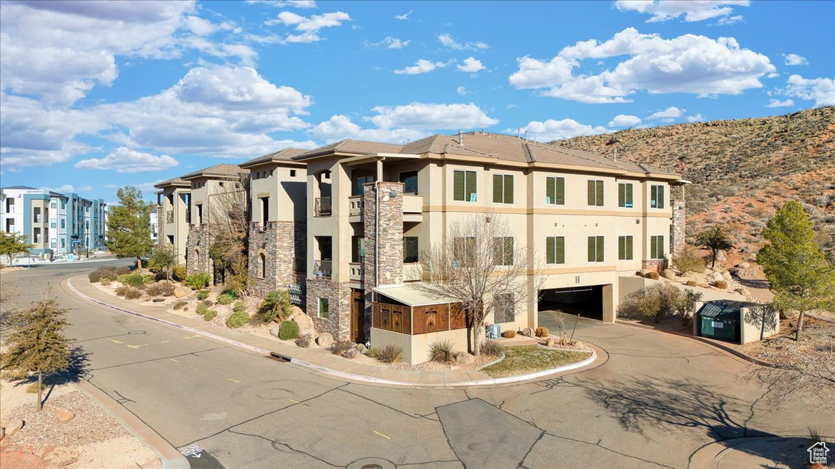View of property with a mountain view and a garage