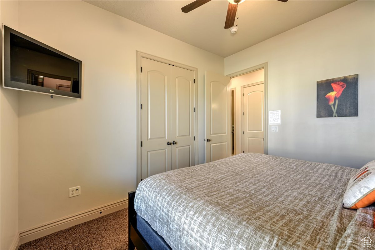 Bedroom featuring ceiling fan, carpet floors, and a baseboard radiator