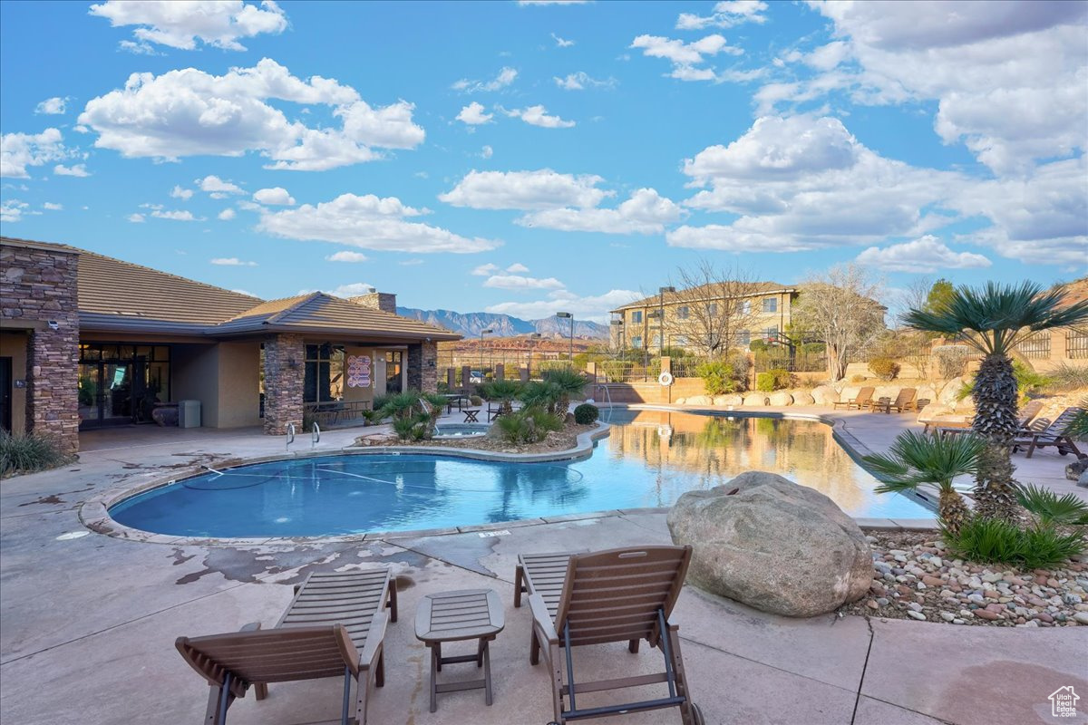 View of swimming pool with a mountain view and a patio
