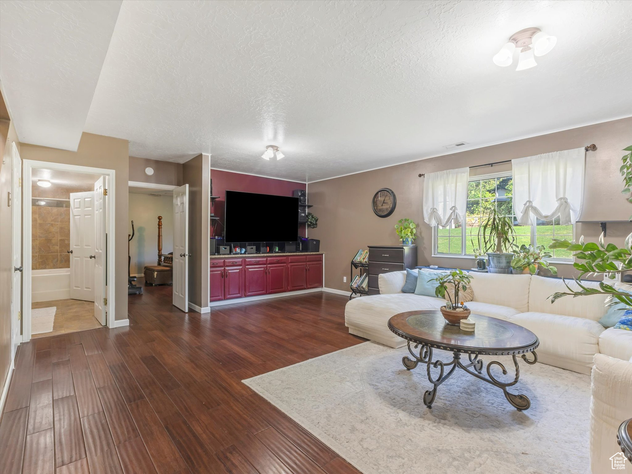 Living room with a textured ceiling and dark hardwood / wood-style floors