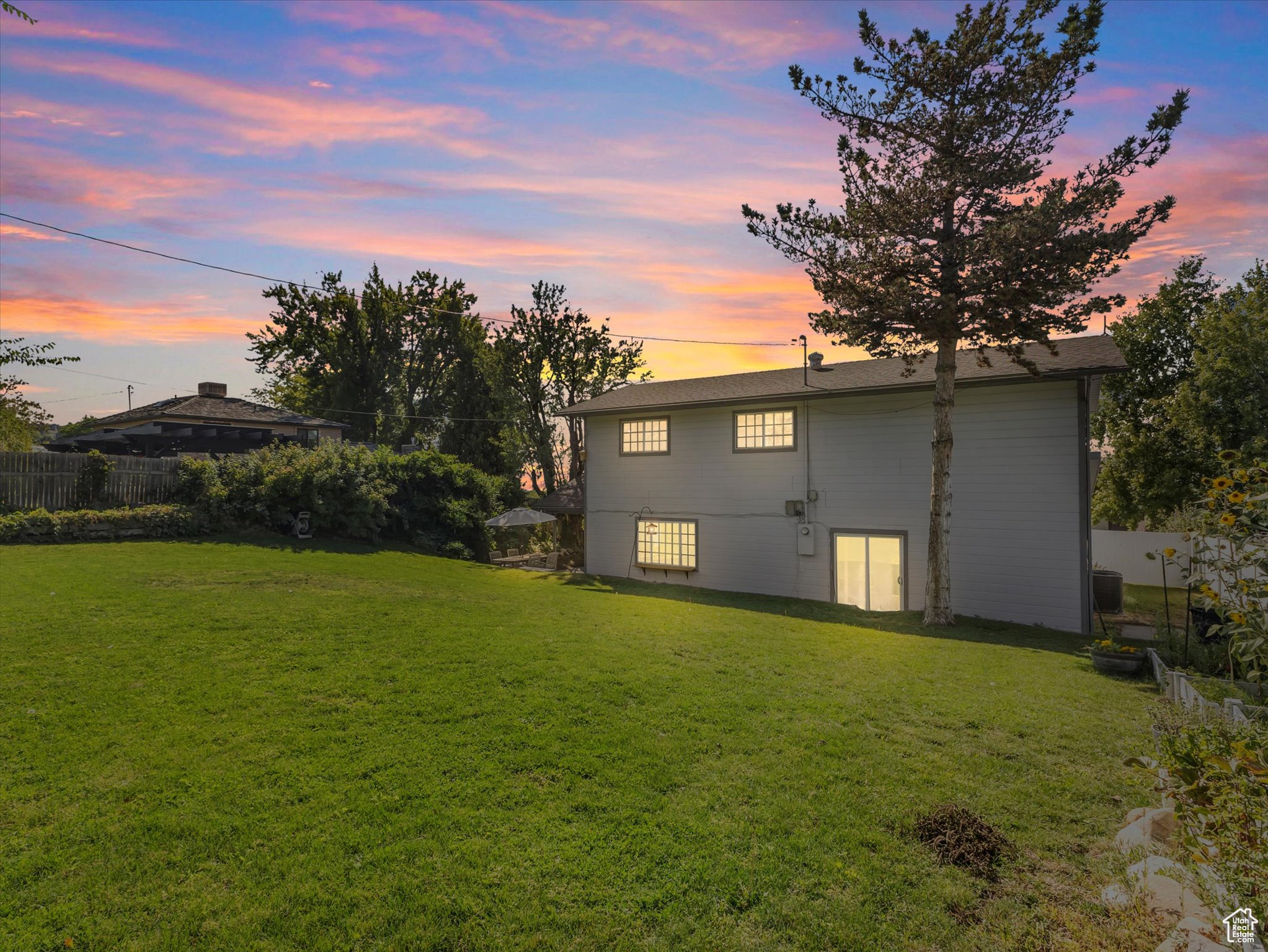 Back house at dusk with a lawn