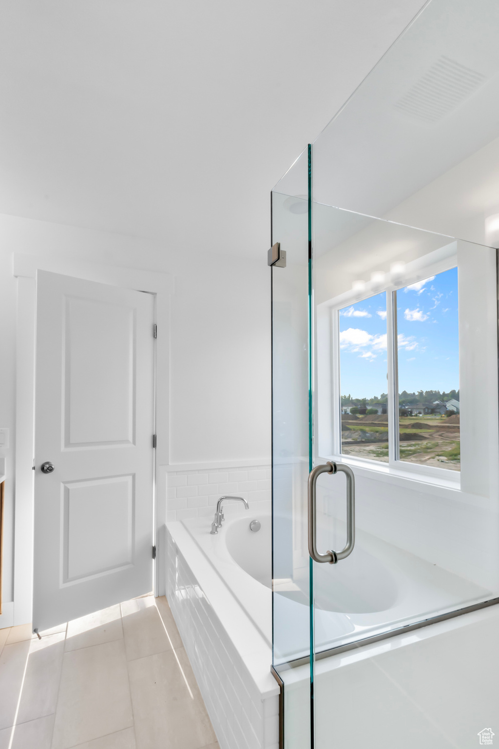 Bathroom featuring tile patterned floors and a relaxing tiled tub