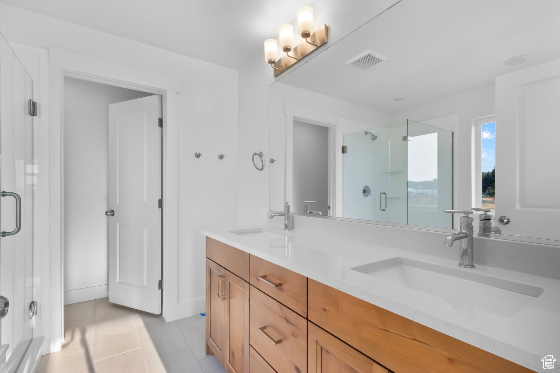 Bathroom with tile patterned floors, vanity, and walk in shower