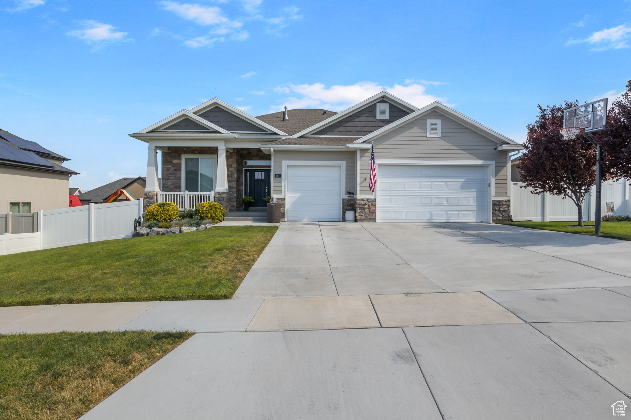 View of front of home featuring covered porch, a front yard, and a garage