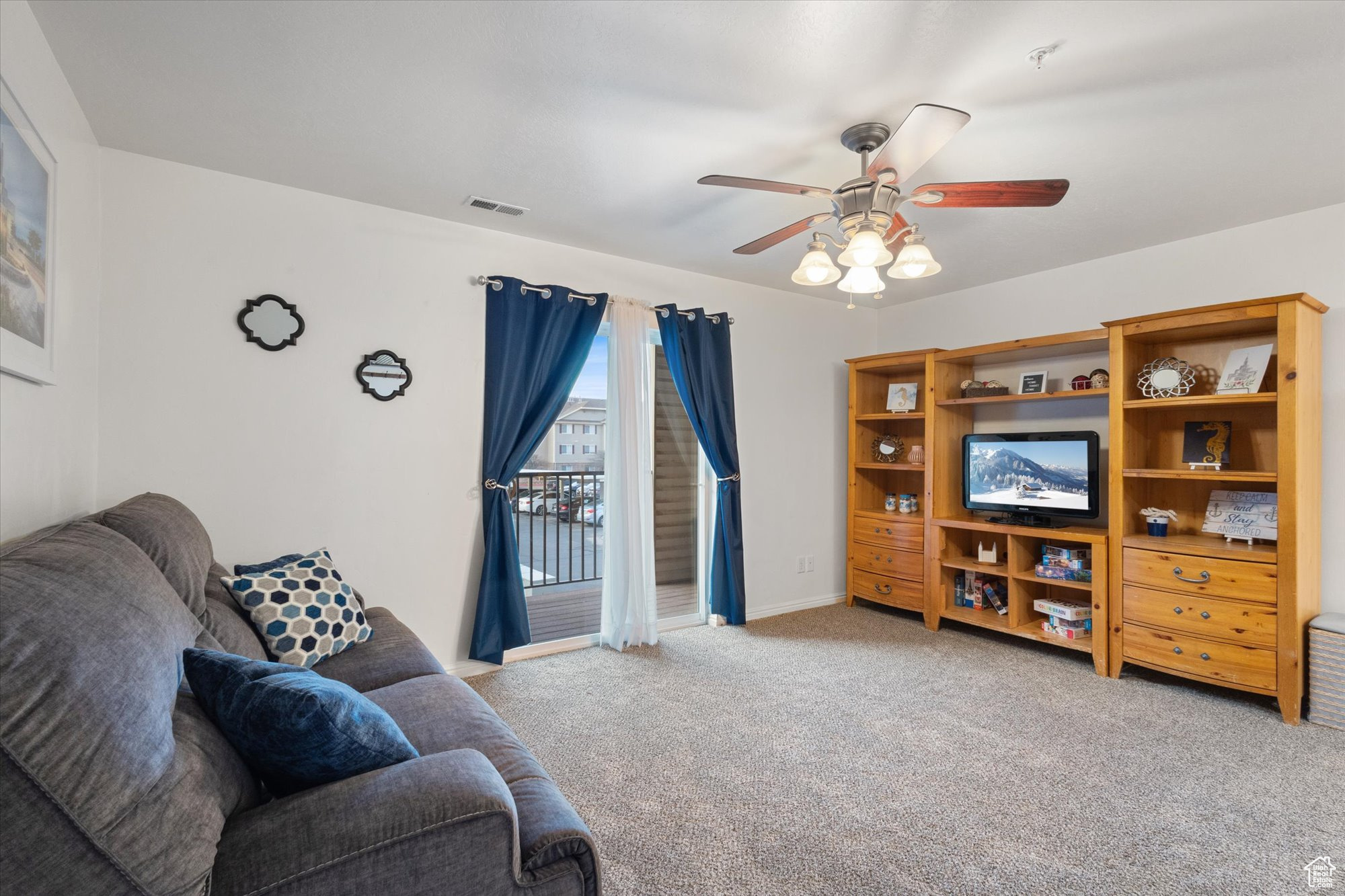 Carpeted living room with ceiling fan