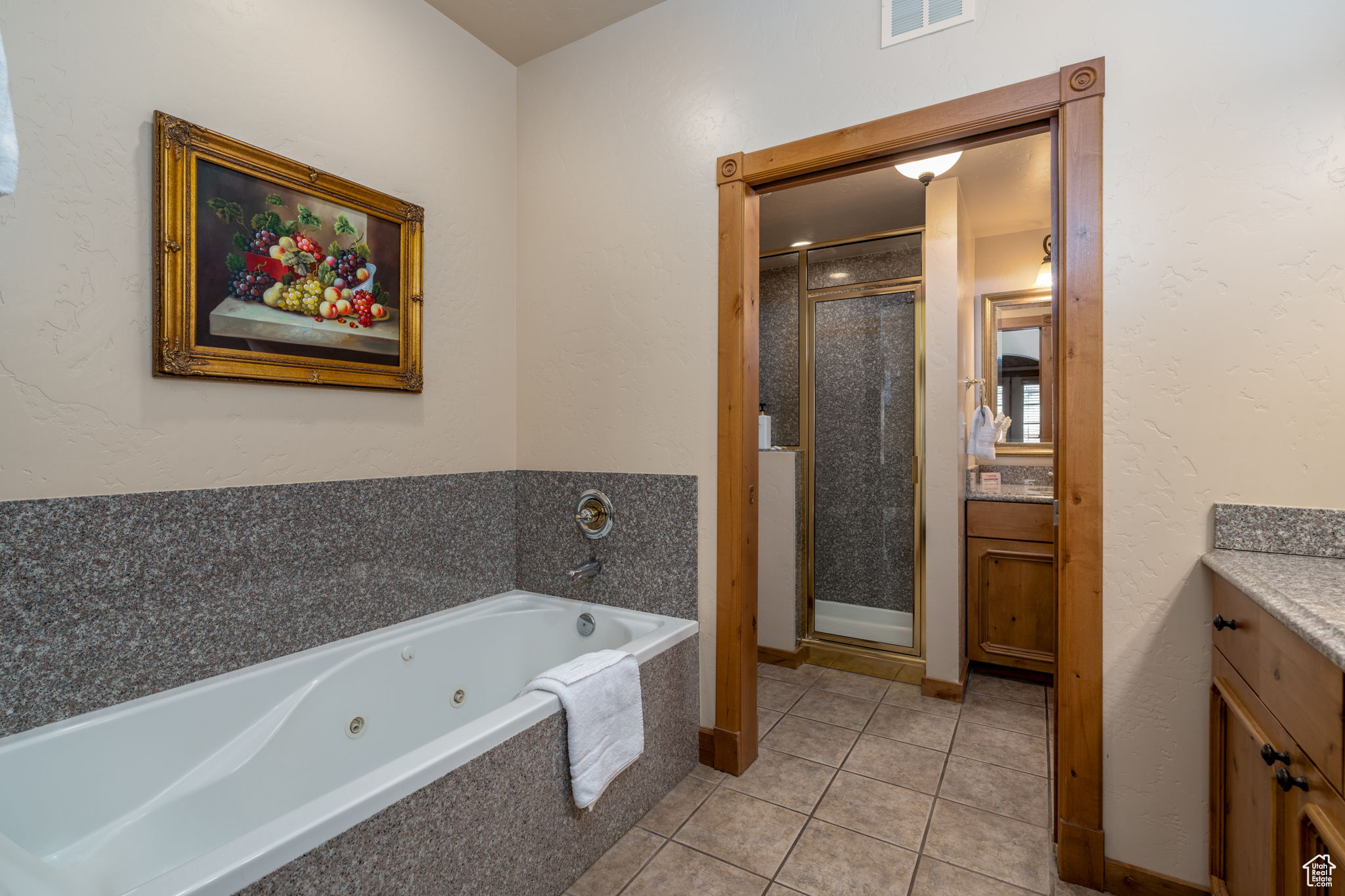 Bathroom with vanity, tile patterned floors, and independent shower and bath