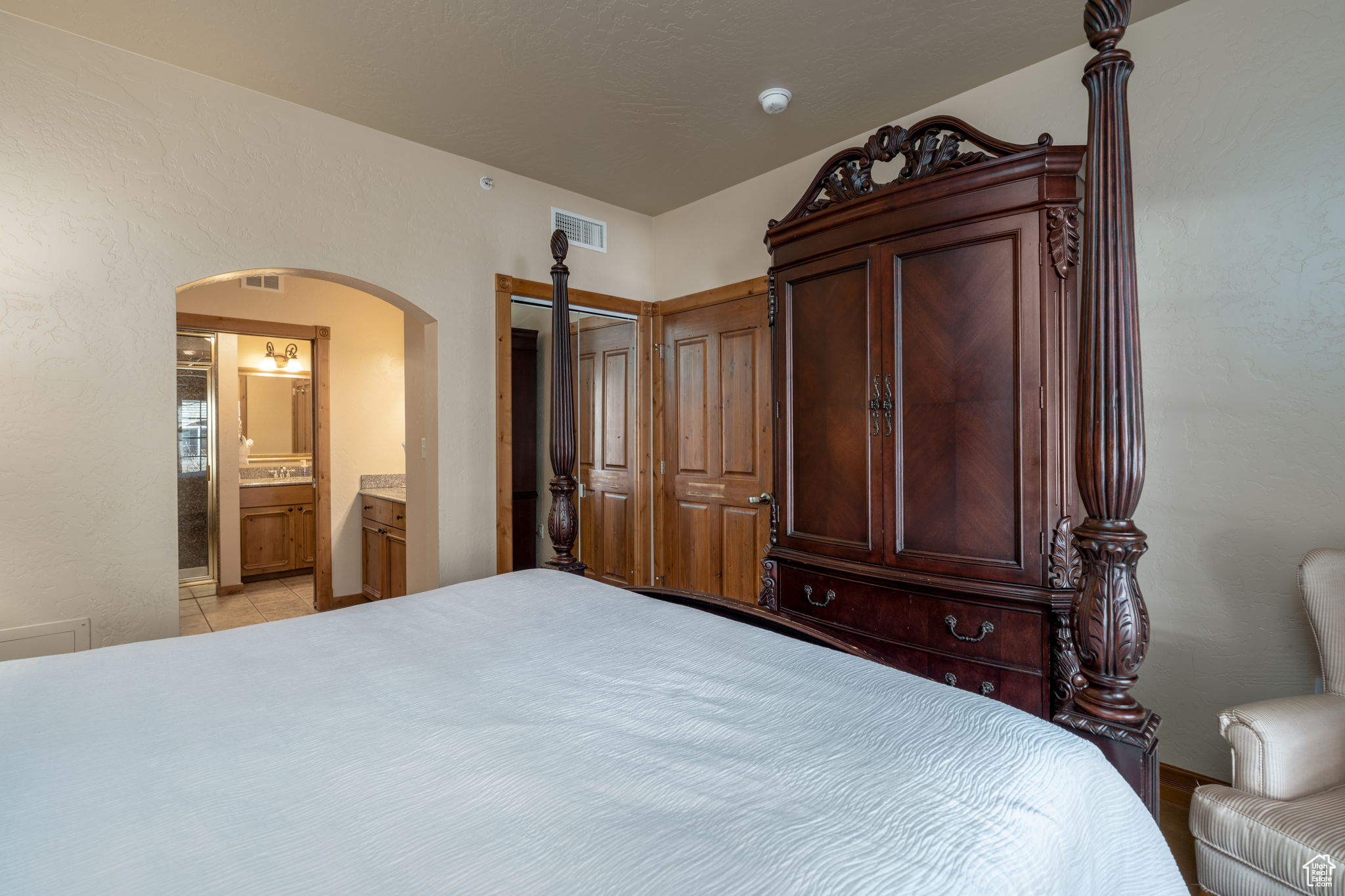 Tiled bedroom with ensuite bathroom and a closet