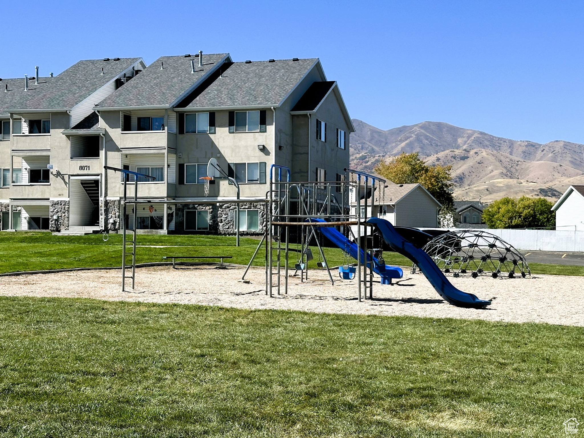 View of jungle gym with a mountain view and a lawn
