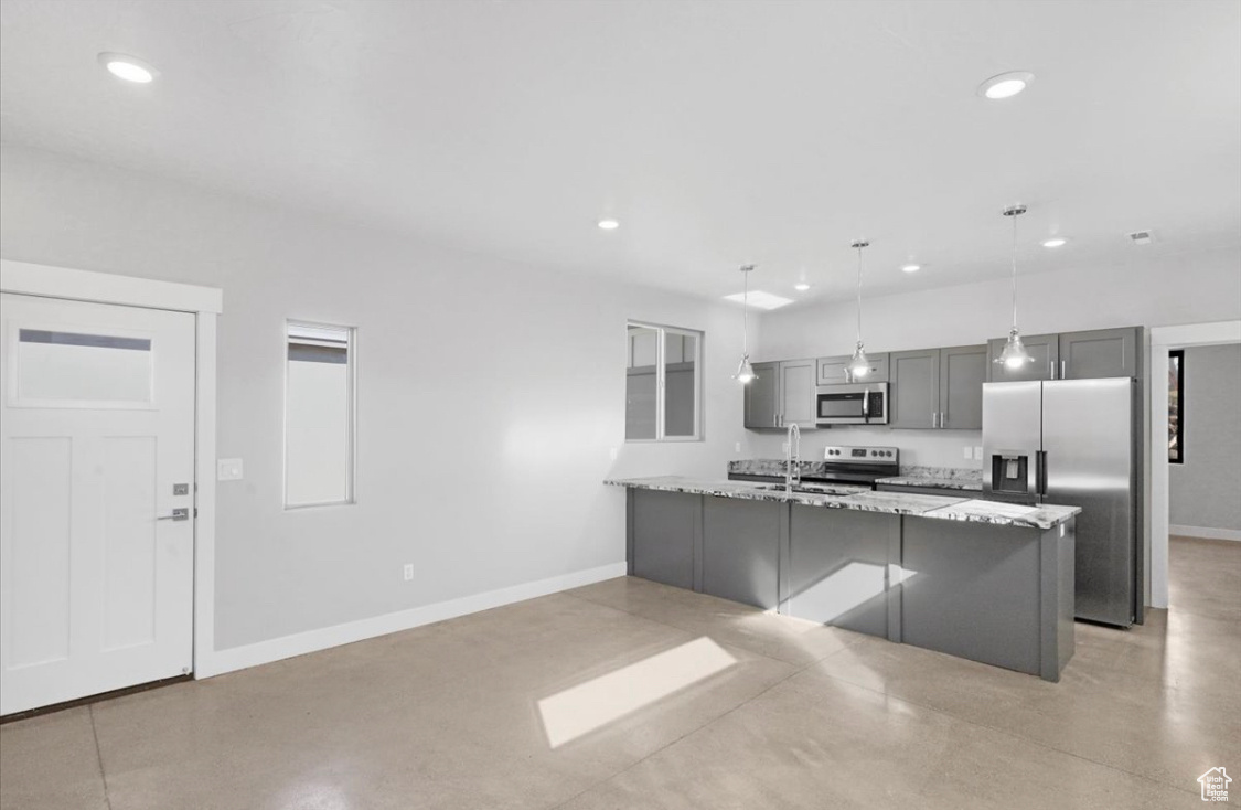 Kitchen with sink, stainless steel appliances, light stone counters, pendant lighting, and gray cabinets