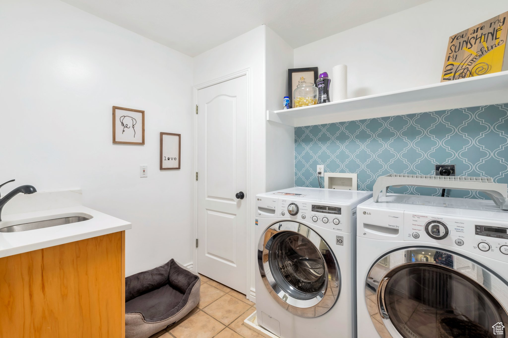 Washroom featuring light tile patterned flooring, independent washer and dryer, and sink