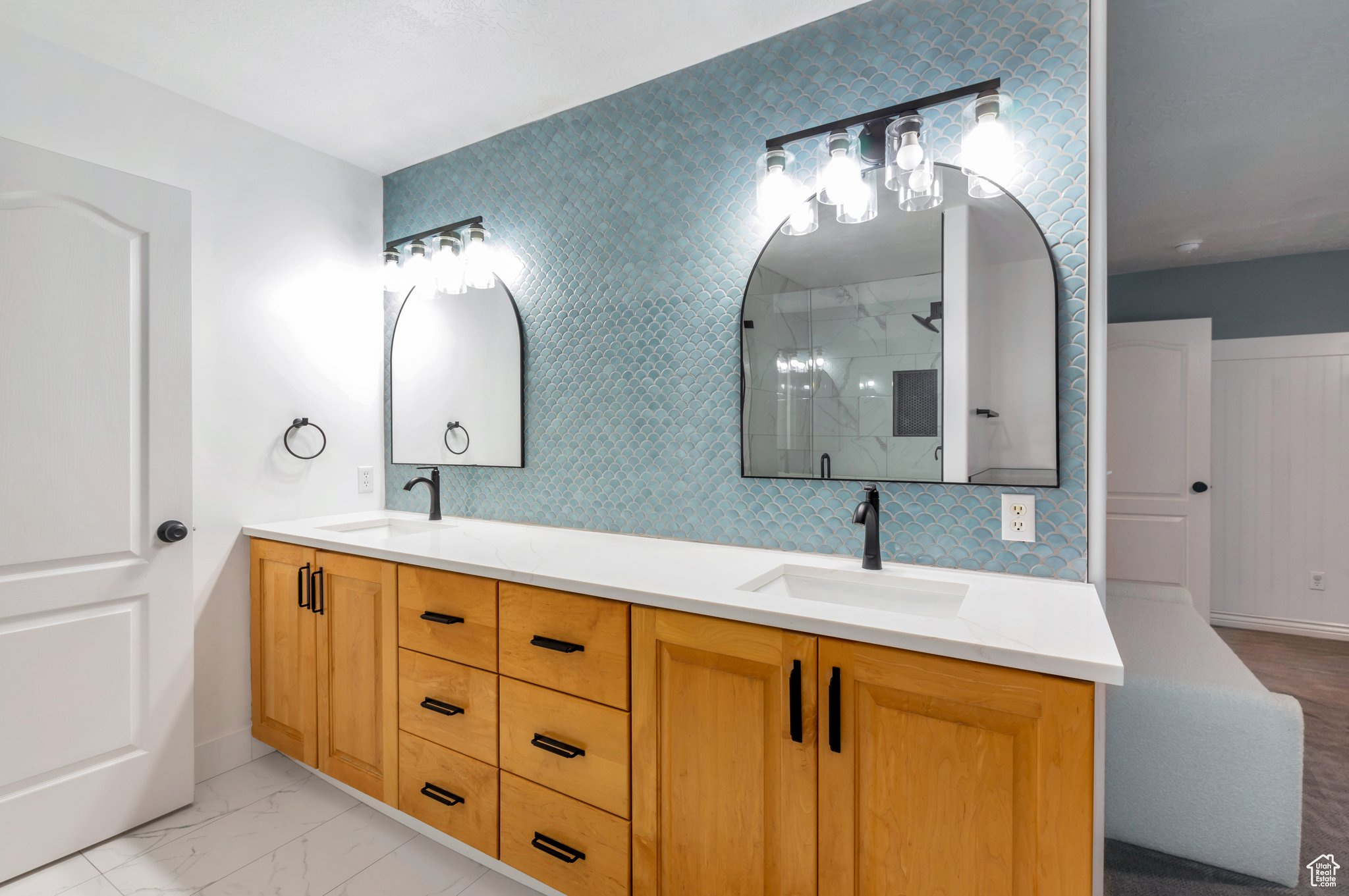 Bathroom featuring vanity, walk in shower, and backsplash