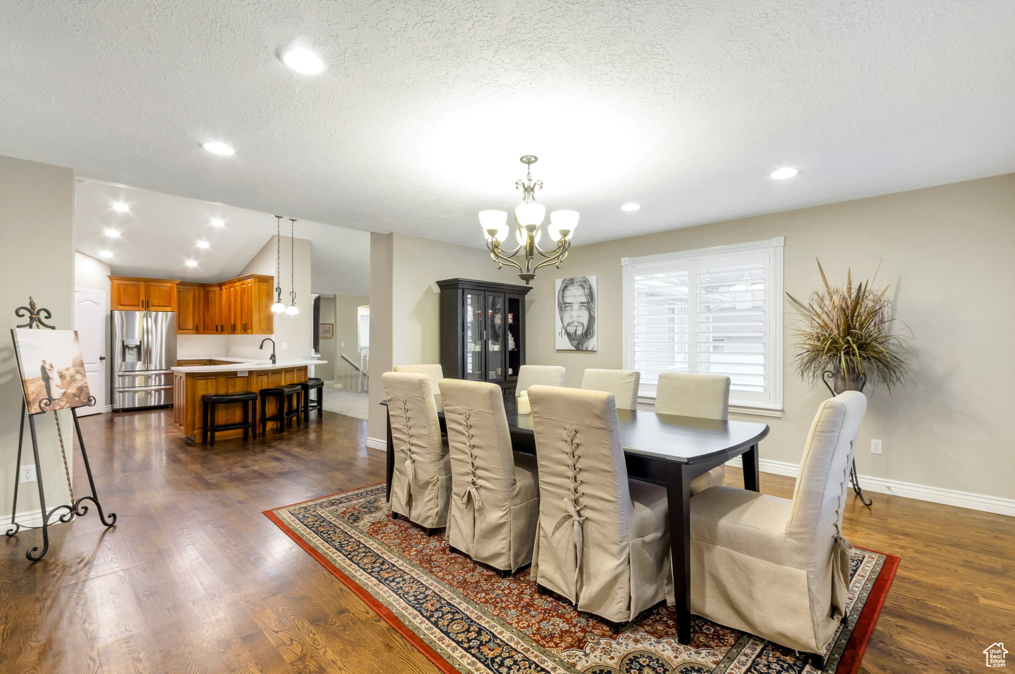 Dining area featuring dark hardwood / wood-style flooring, a chandelier, a textured ceiling, and sink