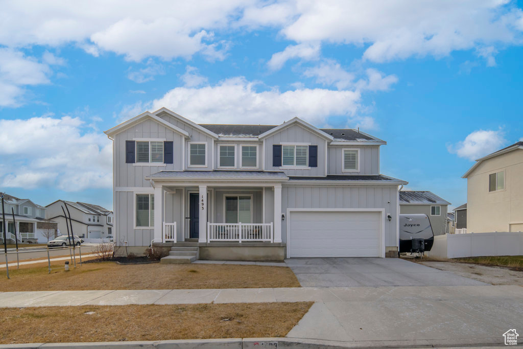 View of front of house with a porch and a garage