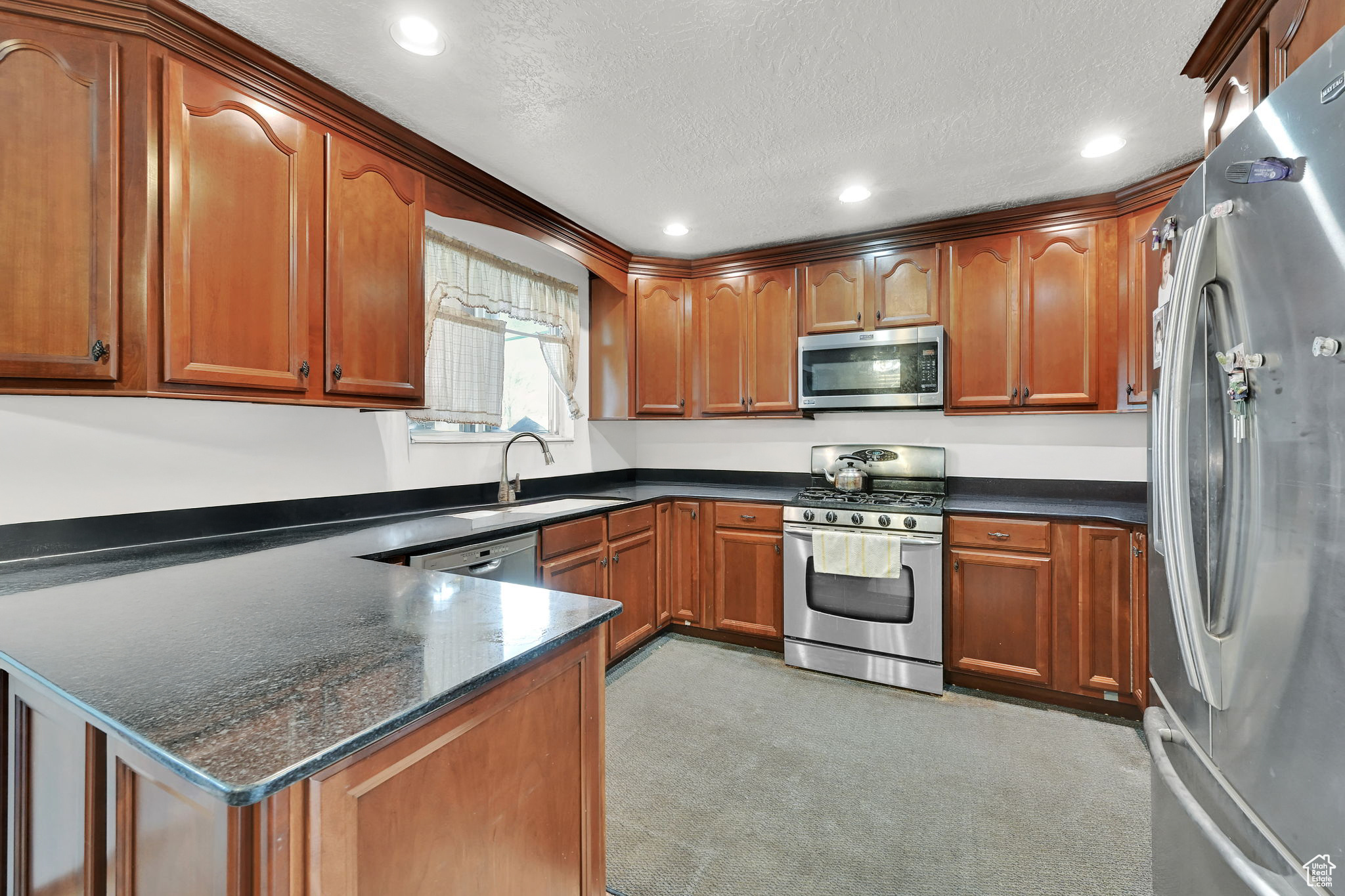 Kitchen featuring granite countertops,  kitchen peninsula, and stainless steel appliances