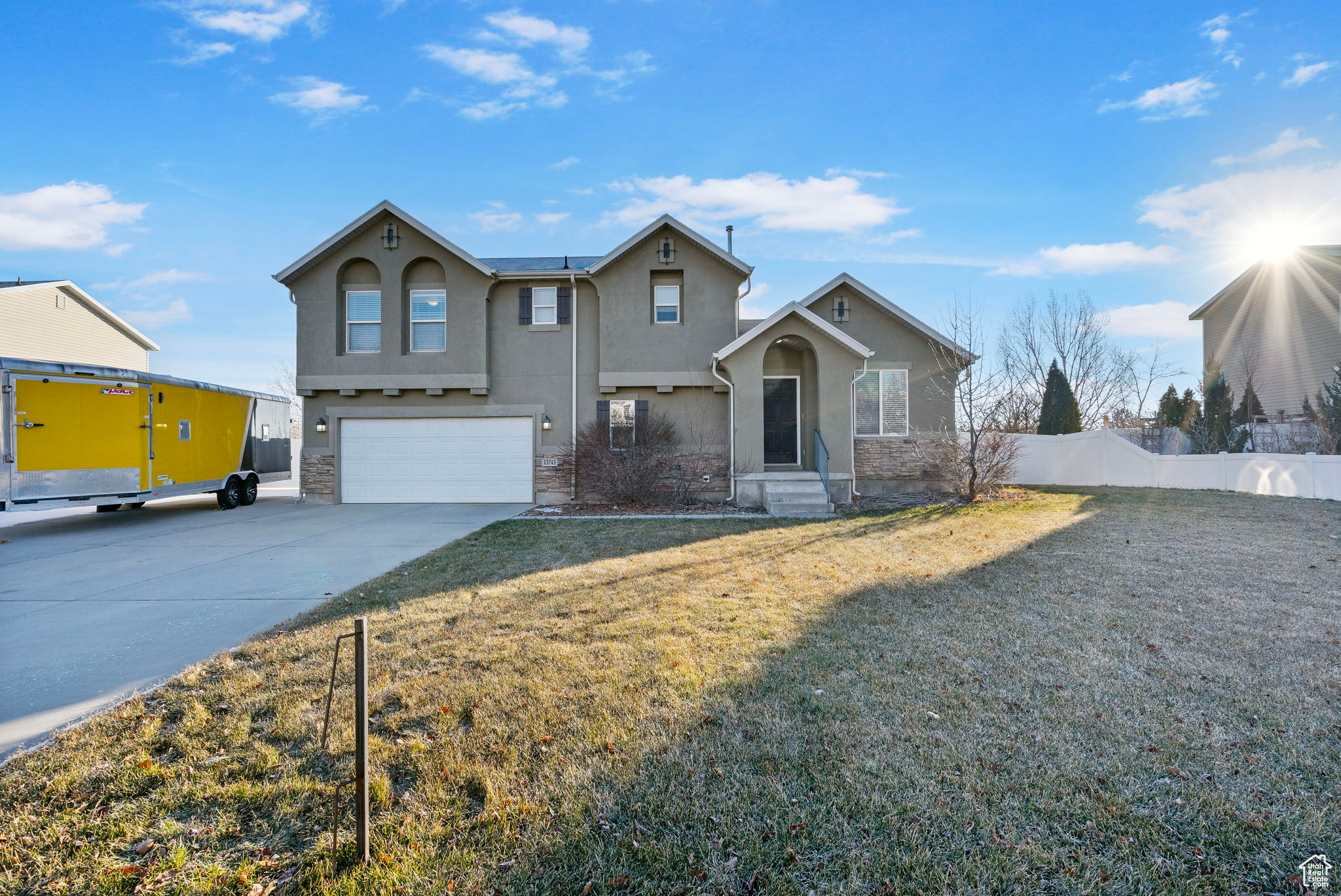 View of property featuring a garage and a front lawn