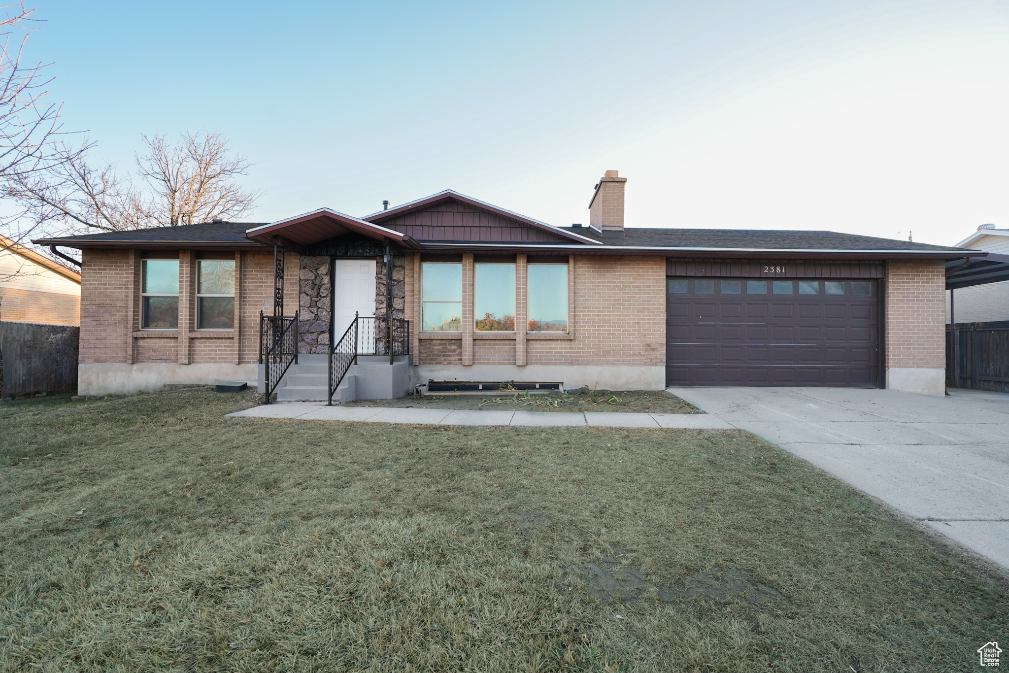 View of front of property featuring a front yard and a garage