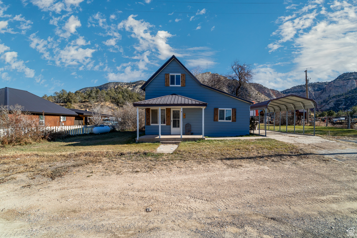 View of front of property featuring covered porch, a mountain view, and a carport