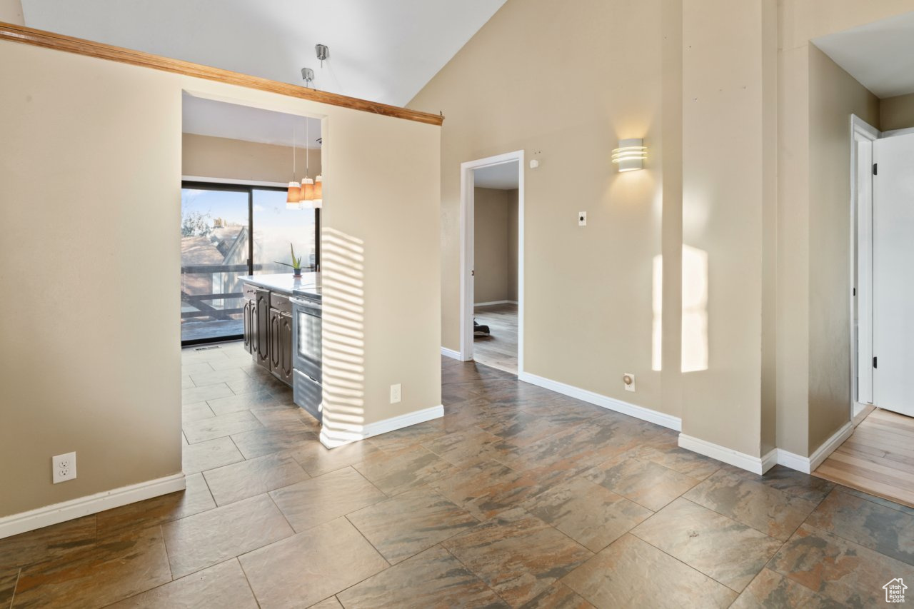 Unfurnished room featuring lofted ceiling