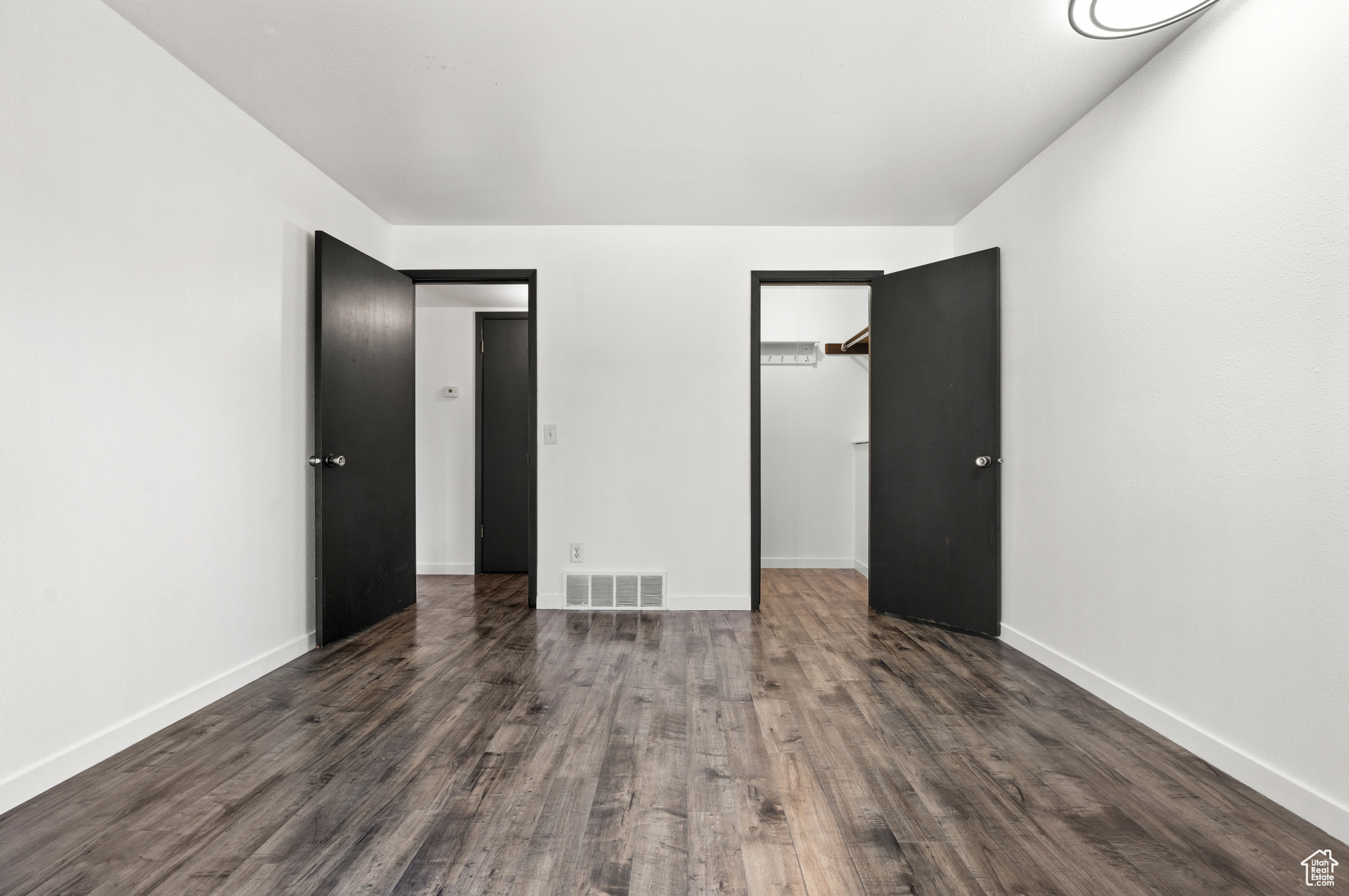 Unfurnished bedroom with dark hardwood / wood-style floors