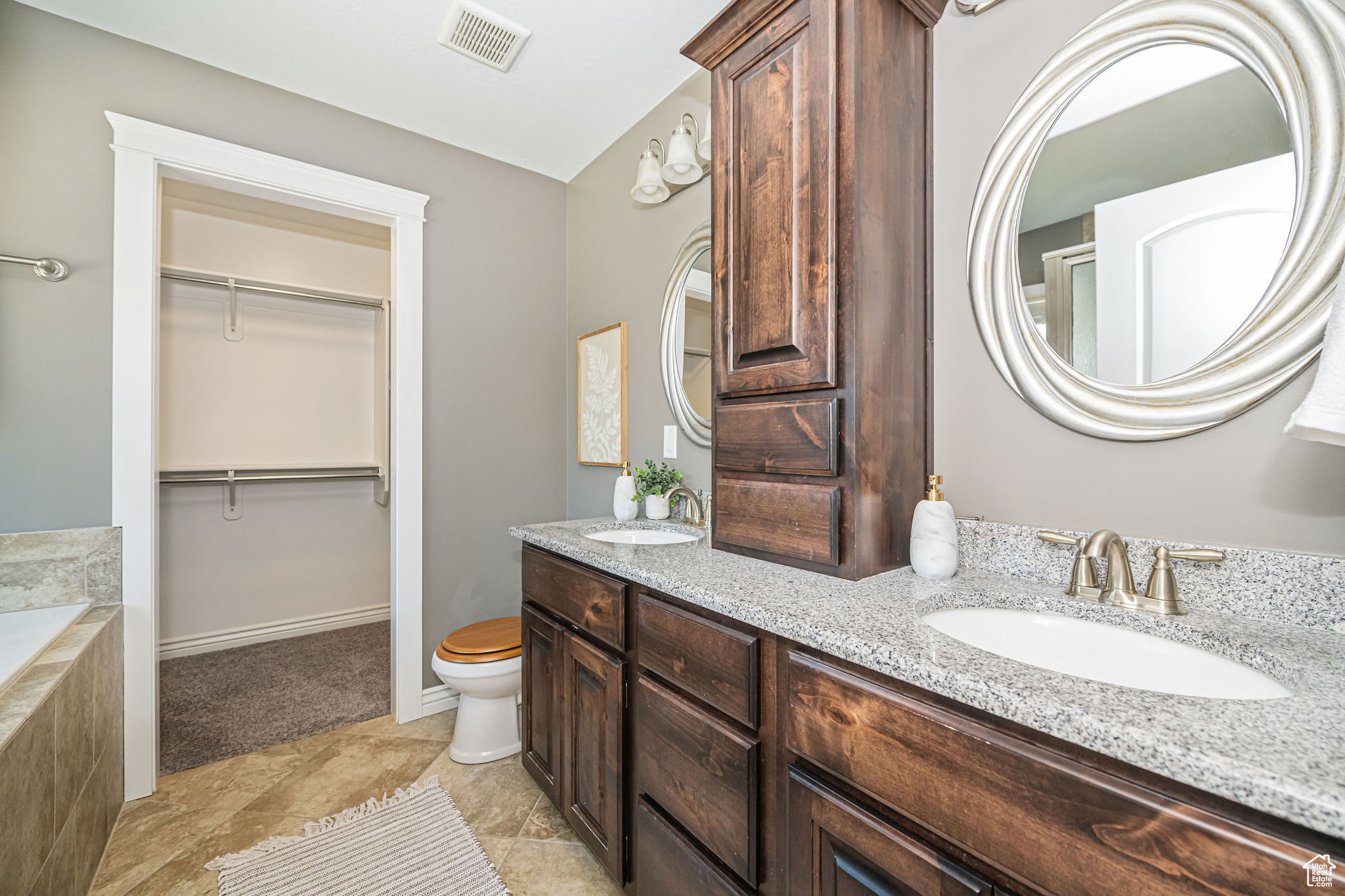 Bathroom with vanity and tiled bath