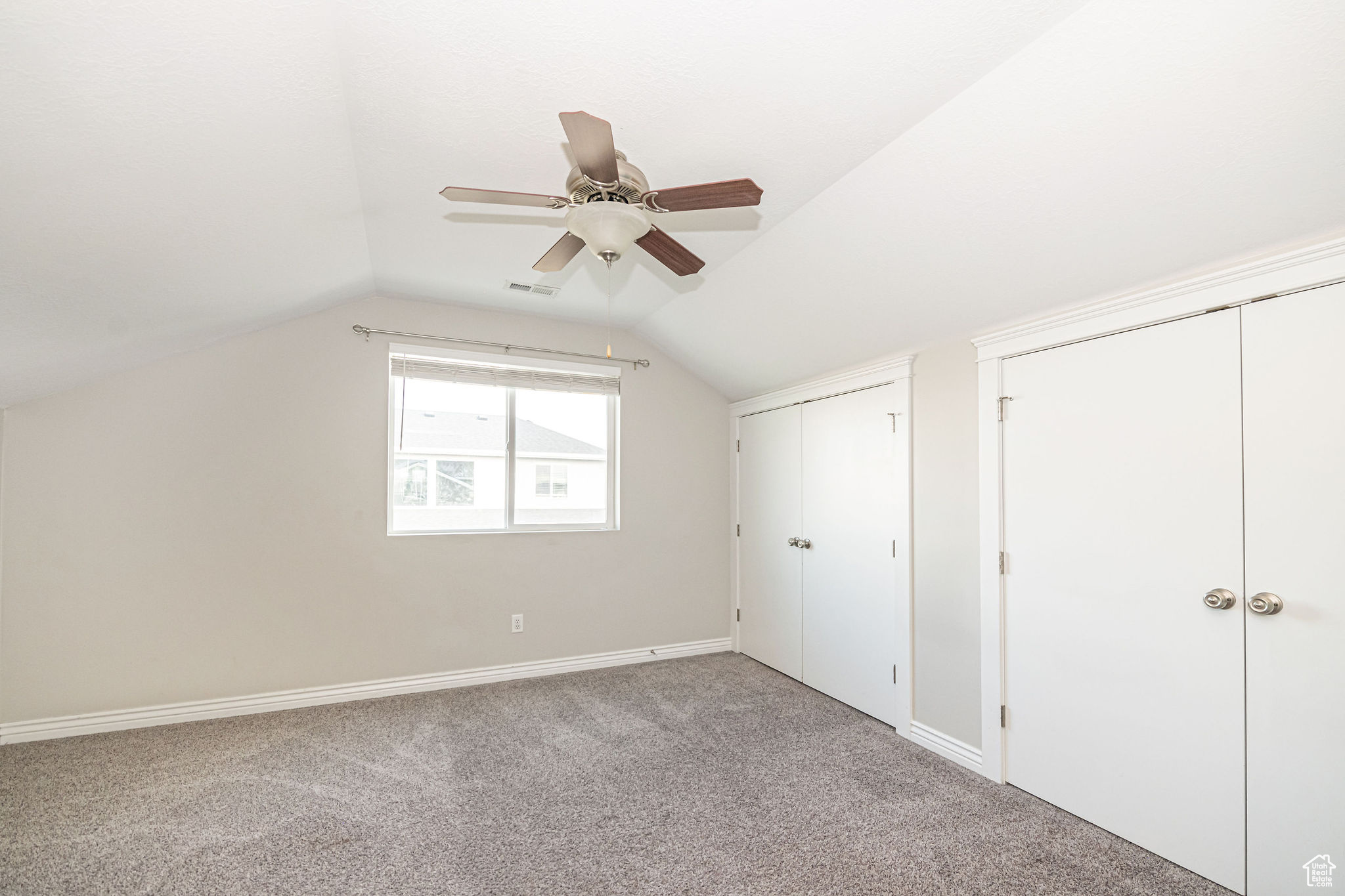 Bonus room with ceiling fan, light colored carpet, and lofted ceiling