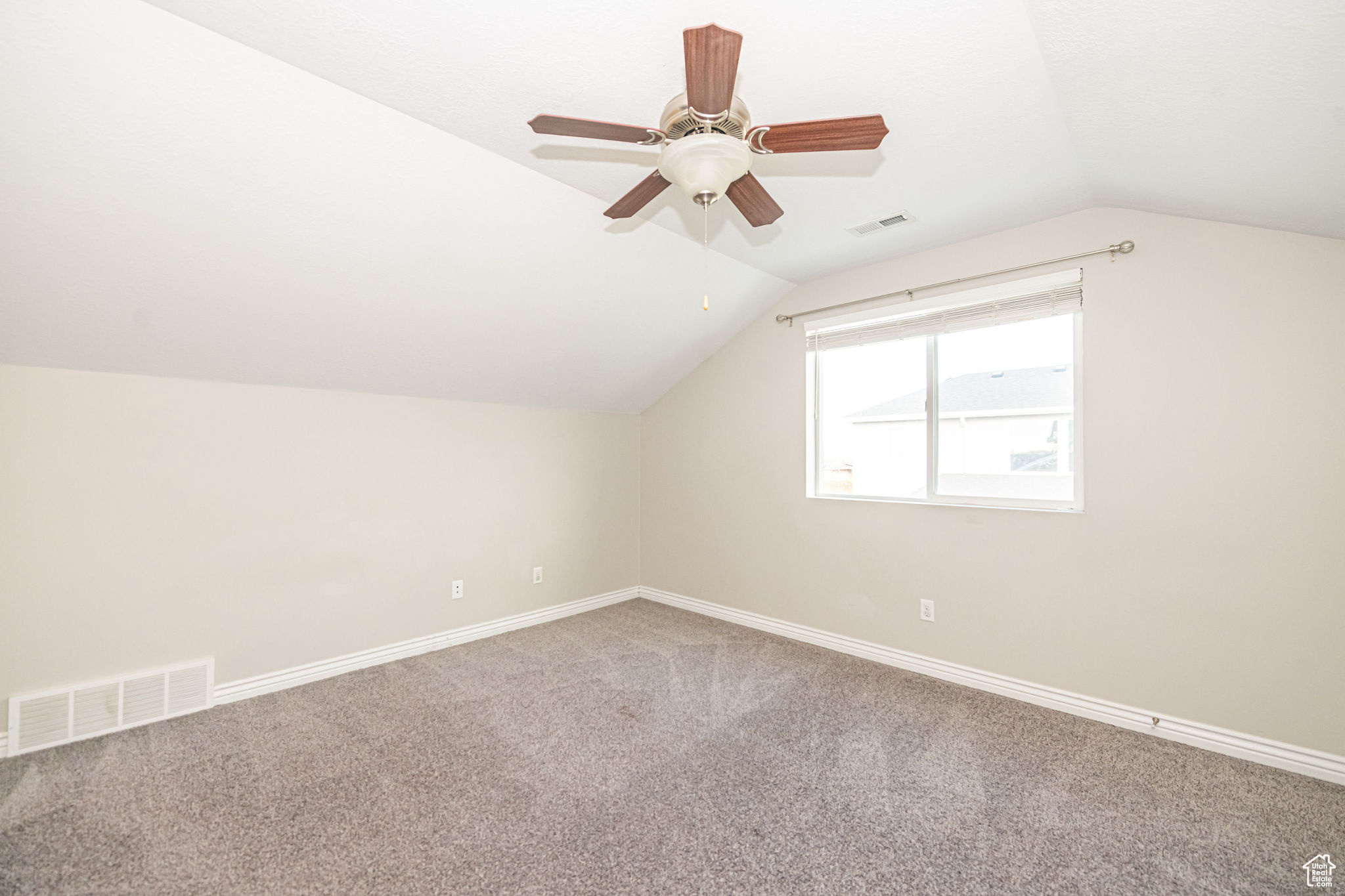 Additional living space featuring lofted ceiling, carpet flooring, and ceiling fan