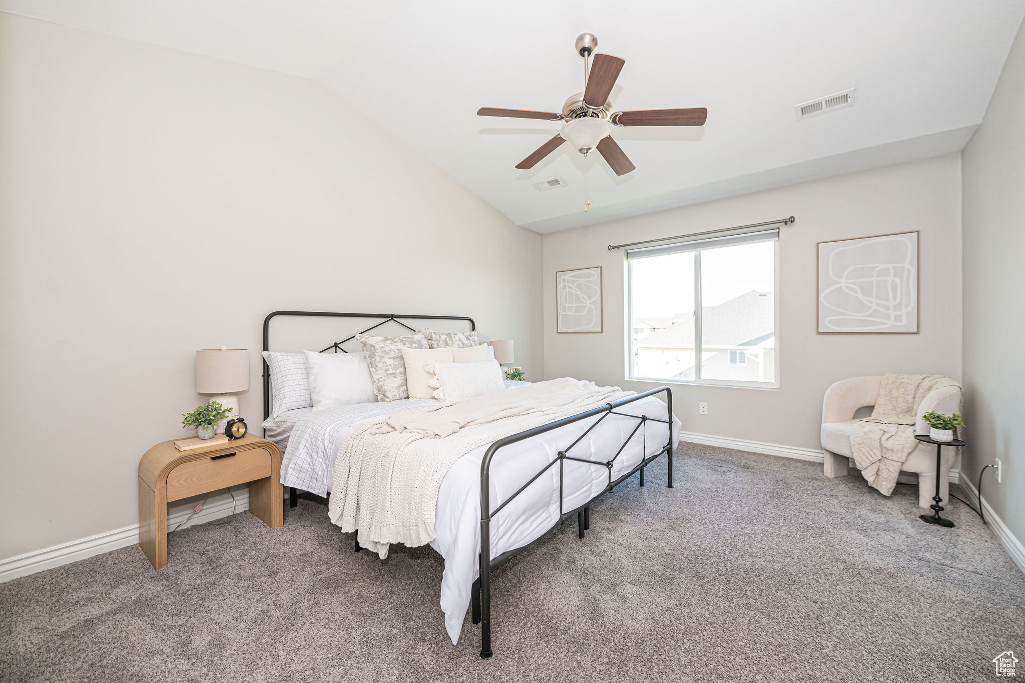 Carpeted bedroom with vaulted ceiling and ceiling fan