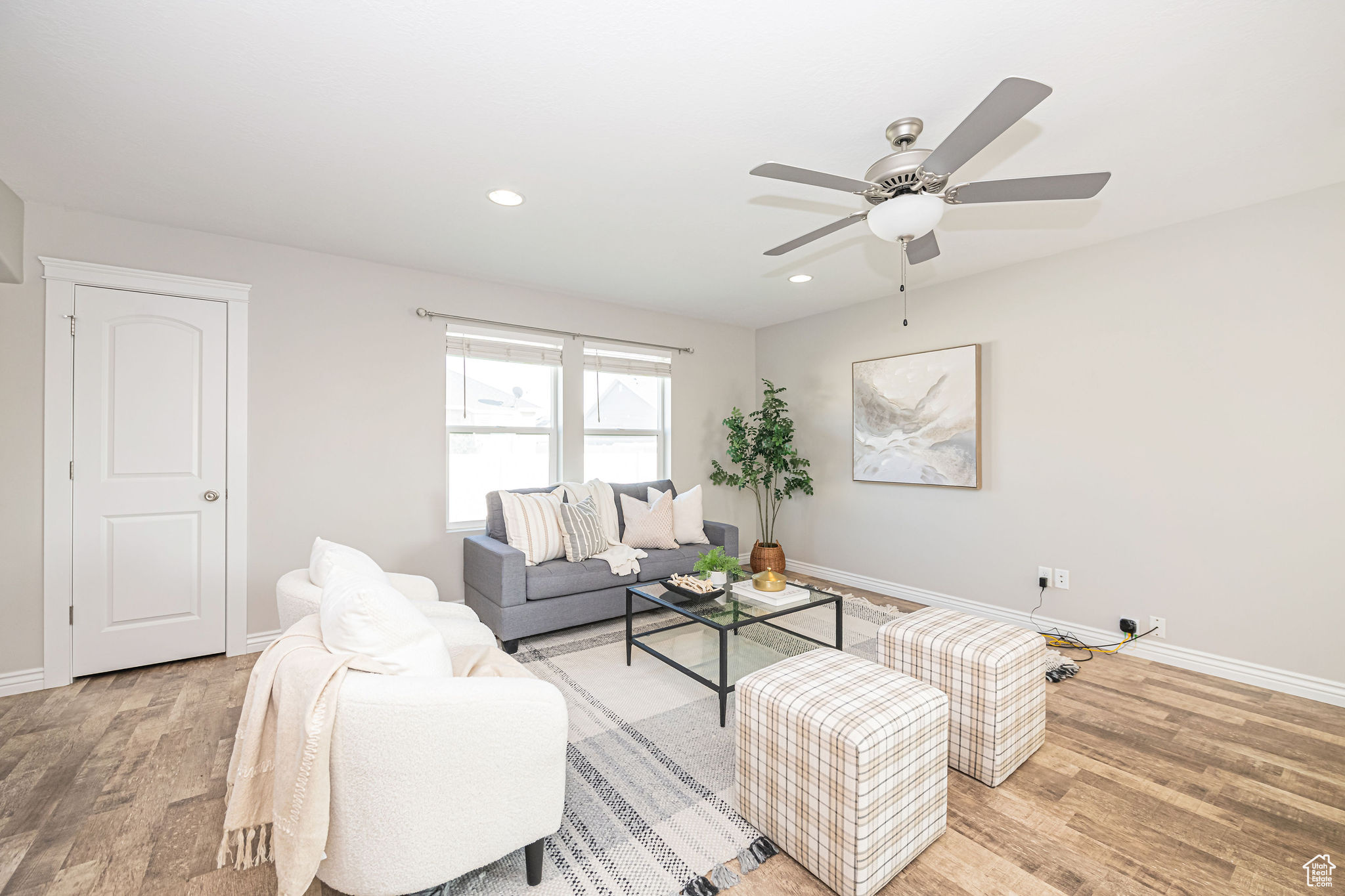 Living room with ceiling fan and hardwood / wood-style floors