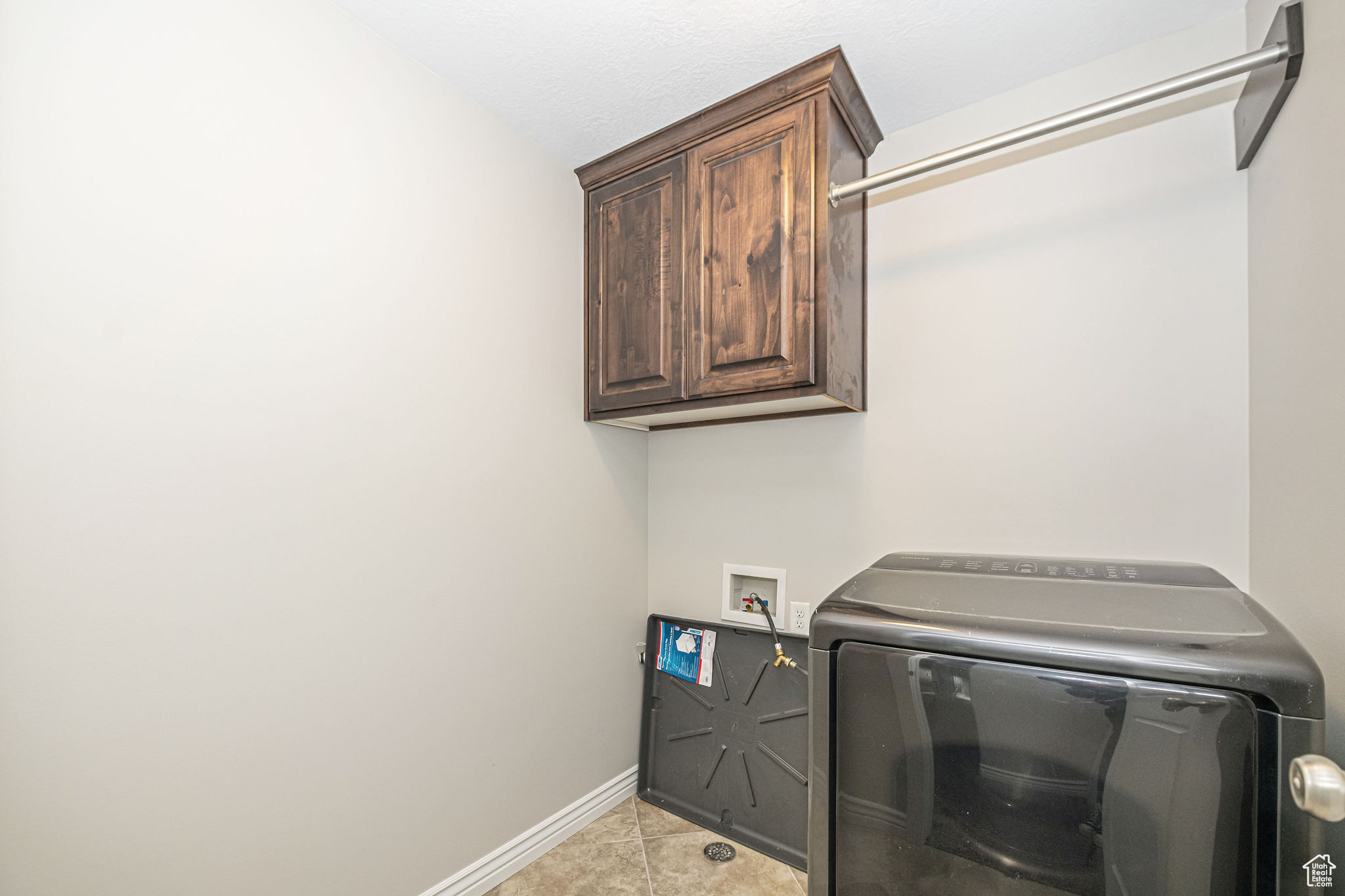 Laundry room with washer / clothes dryer, light tile patterned flooring, and cabinets