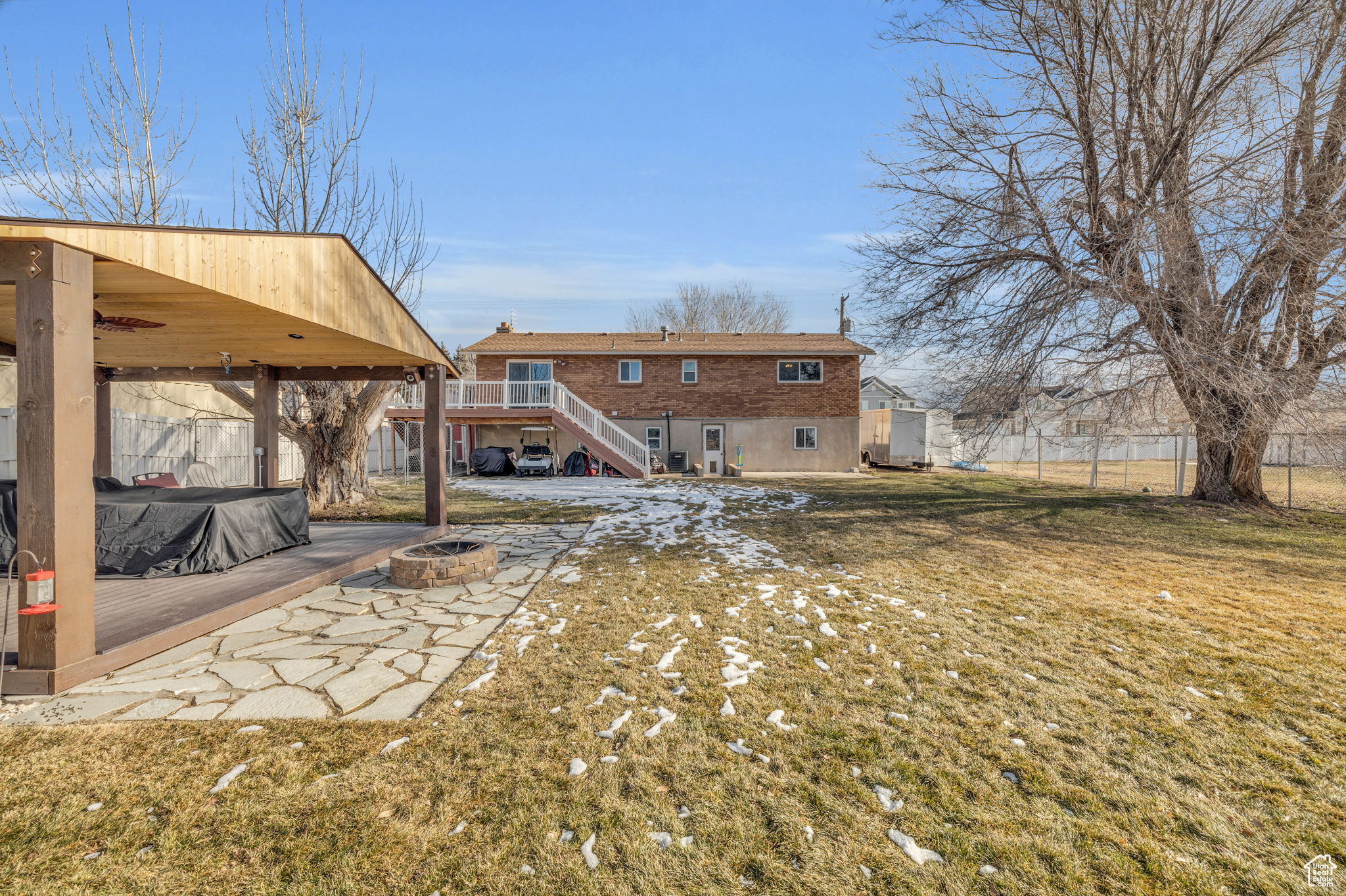 Back of house with a fire pit, a wooden deck, and a yard