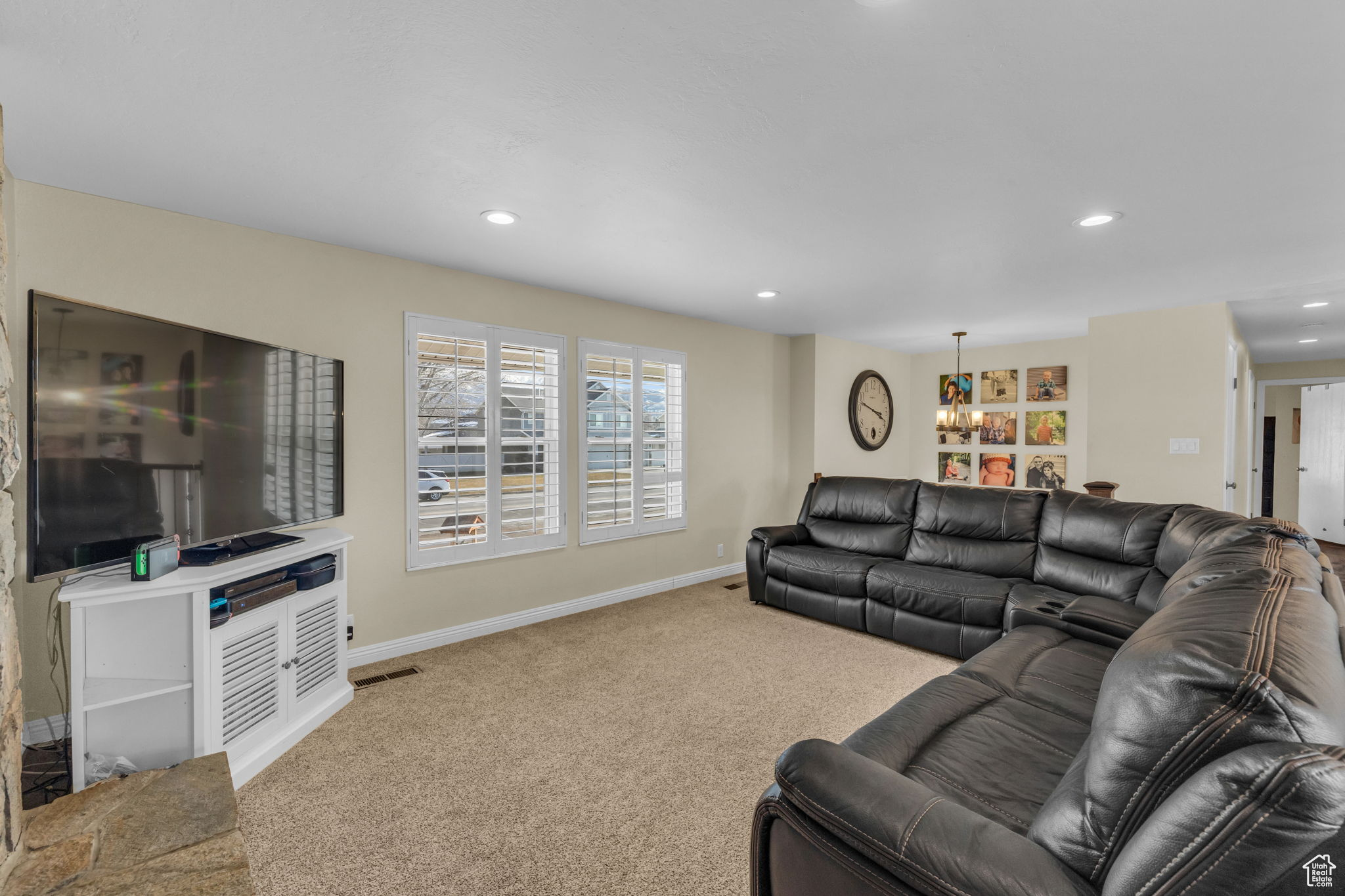 Carpeted living room featuring a notable chandelier