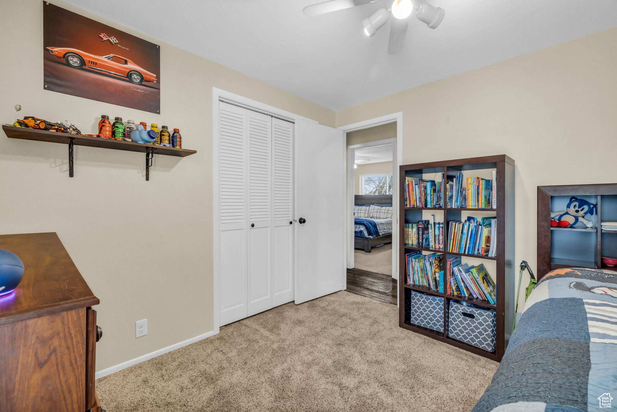 Carpeted bedroom featuring ceiling fan and a closet