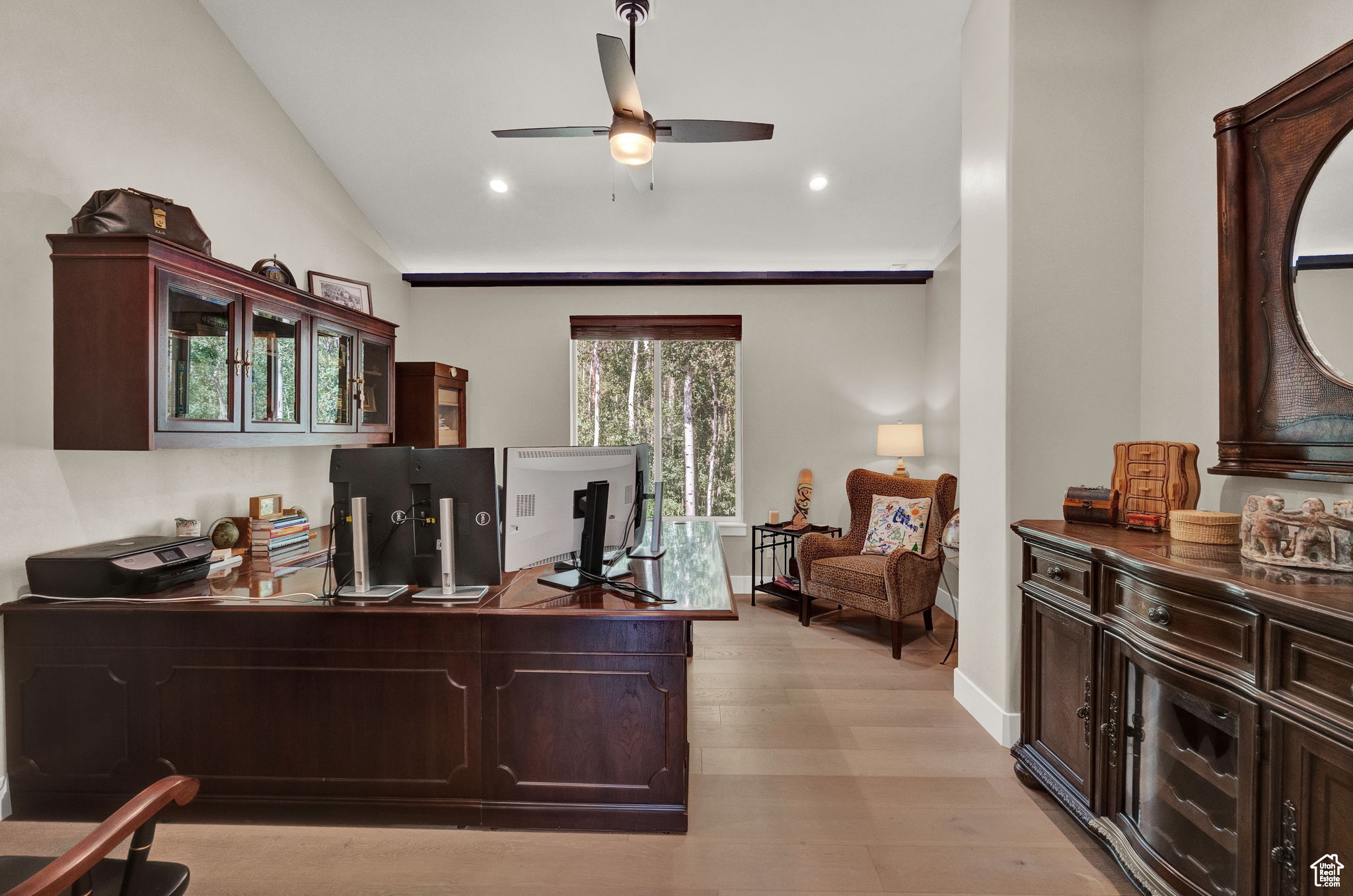 Home office with vaulted ceiling, ceiling fan, and light hardwood / wood-style floors