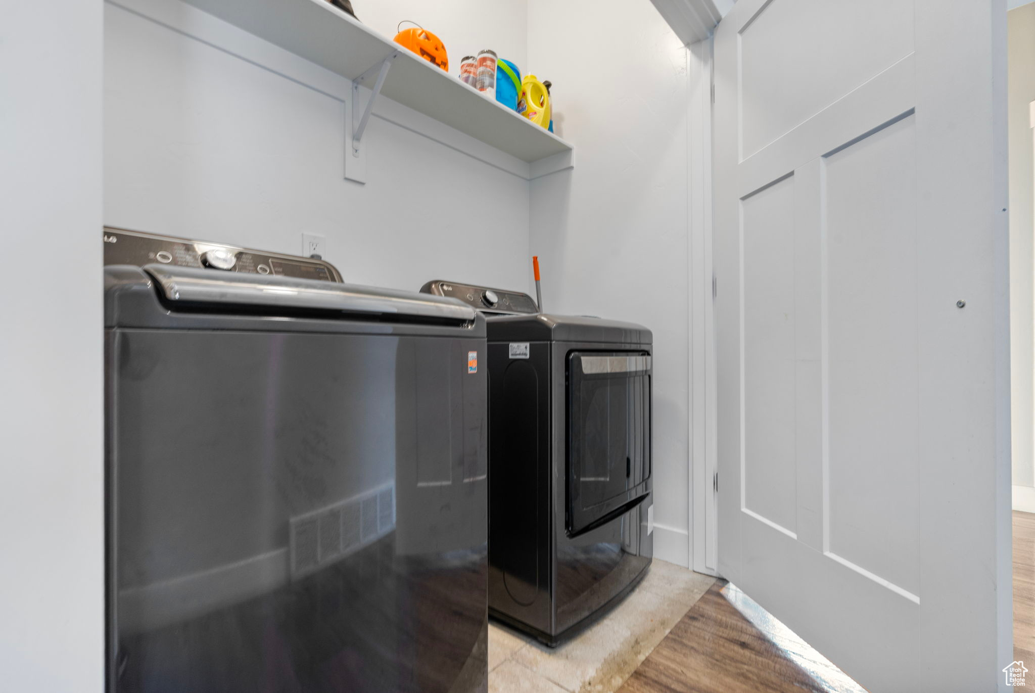 Clothes washing area featuring washer and dryer and light wood-type flooring