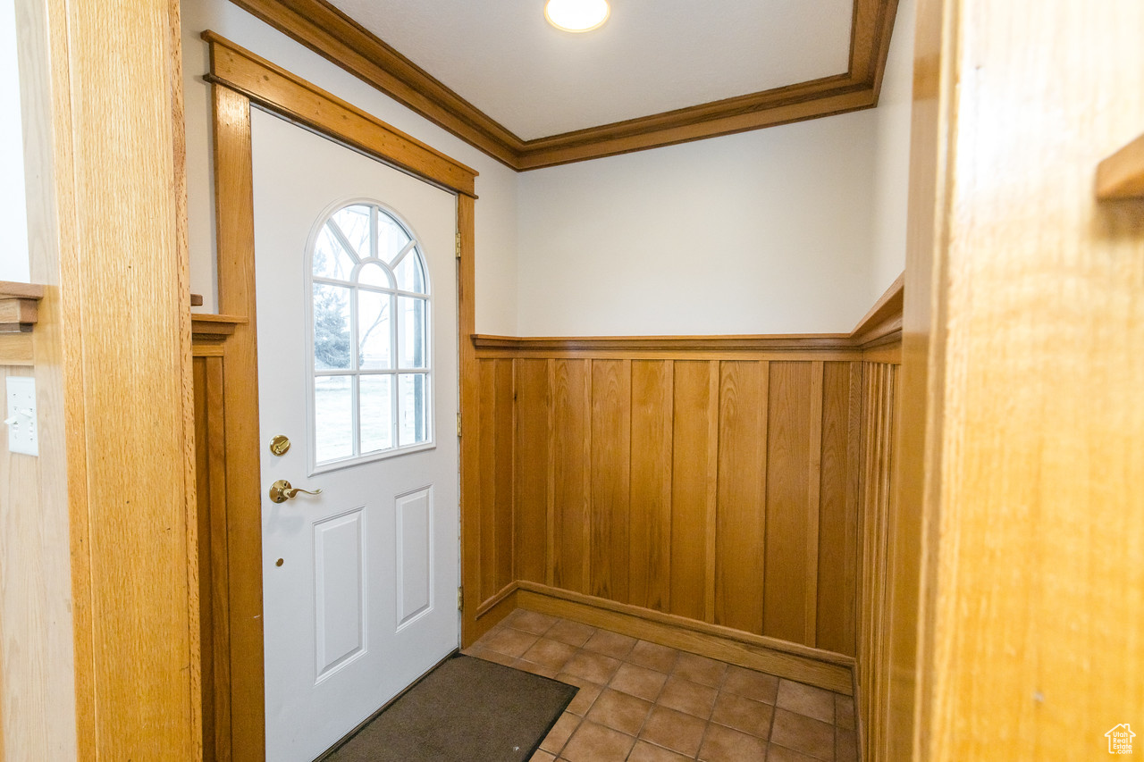 Entrance foyer featuring ornamental oak molding and wooden walls