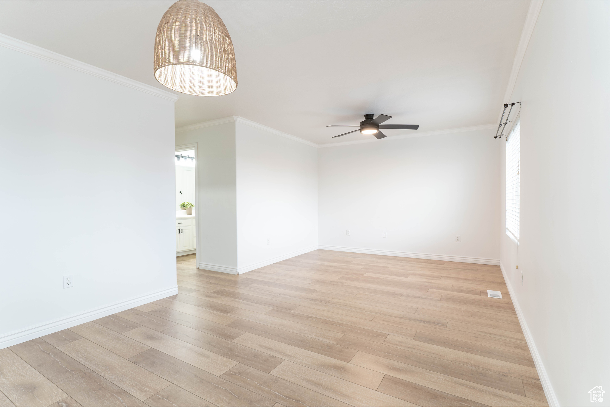 Unfurnished room featuring ornamental molding, ceiling fan, and light wood-type flooring