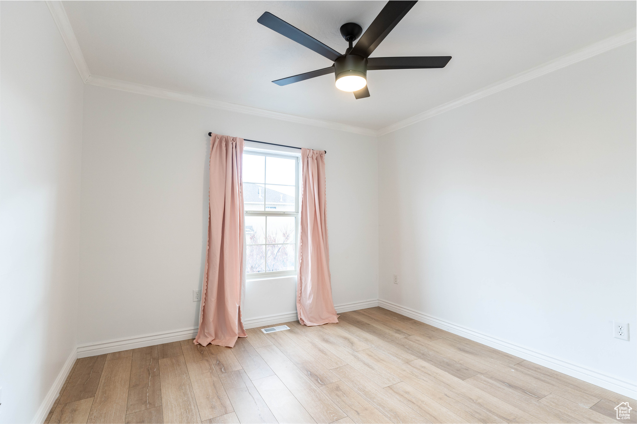 Empty room with ceiling fan, light hardwood / wood-style floors, and crown molding