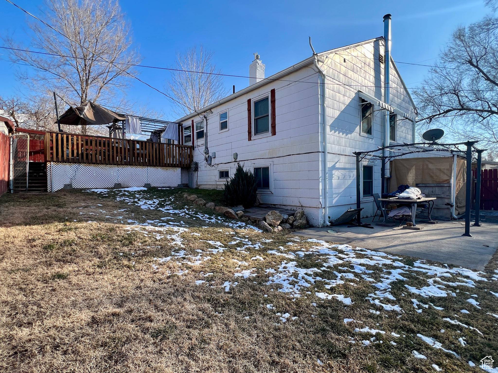 Snow covered rear of property with a deck